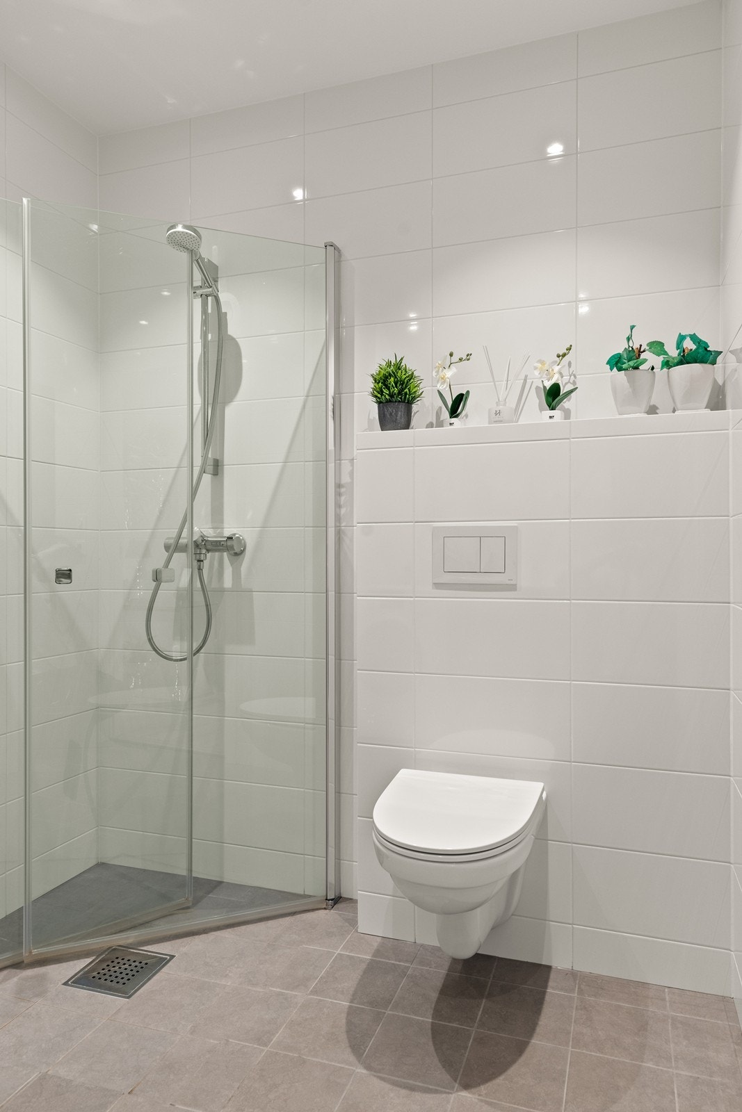 Dette badet er flislagt, har elektriske varmekabler i gulvet, veggmontert toalett og dusjvegger. Galleribilde