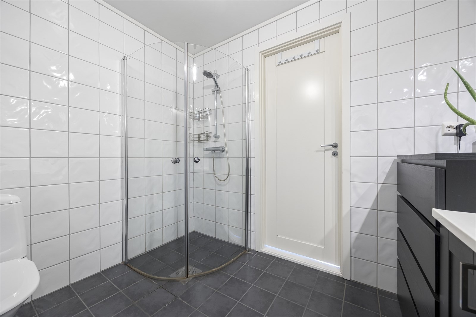 Badet har fliselagt til tak, har servantinnredning, wc og dusjhjørne. Galleribilde