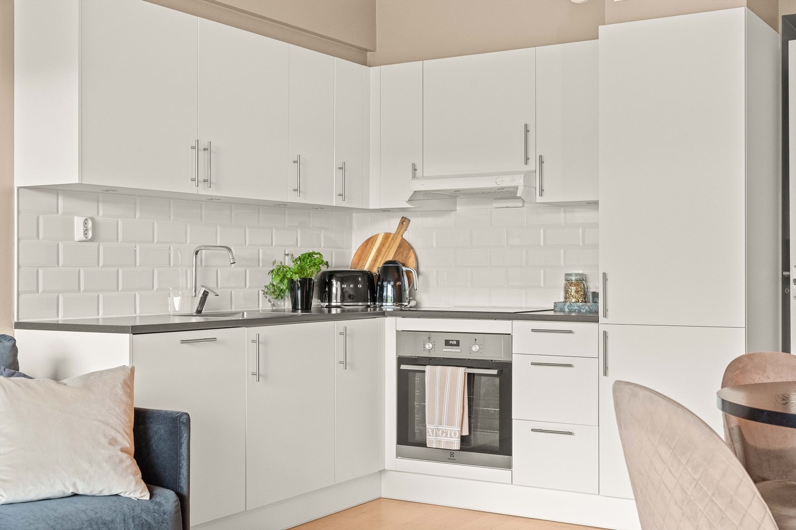 Moderne kjøkken med hvit, stilren innredning og integrerte hvitevarer. Den åpne løsningen gjør matlagingen sosial og gir god kontakt med stue og spiseplass. Galleribilde