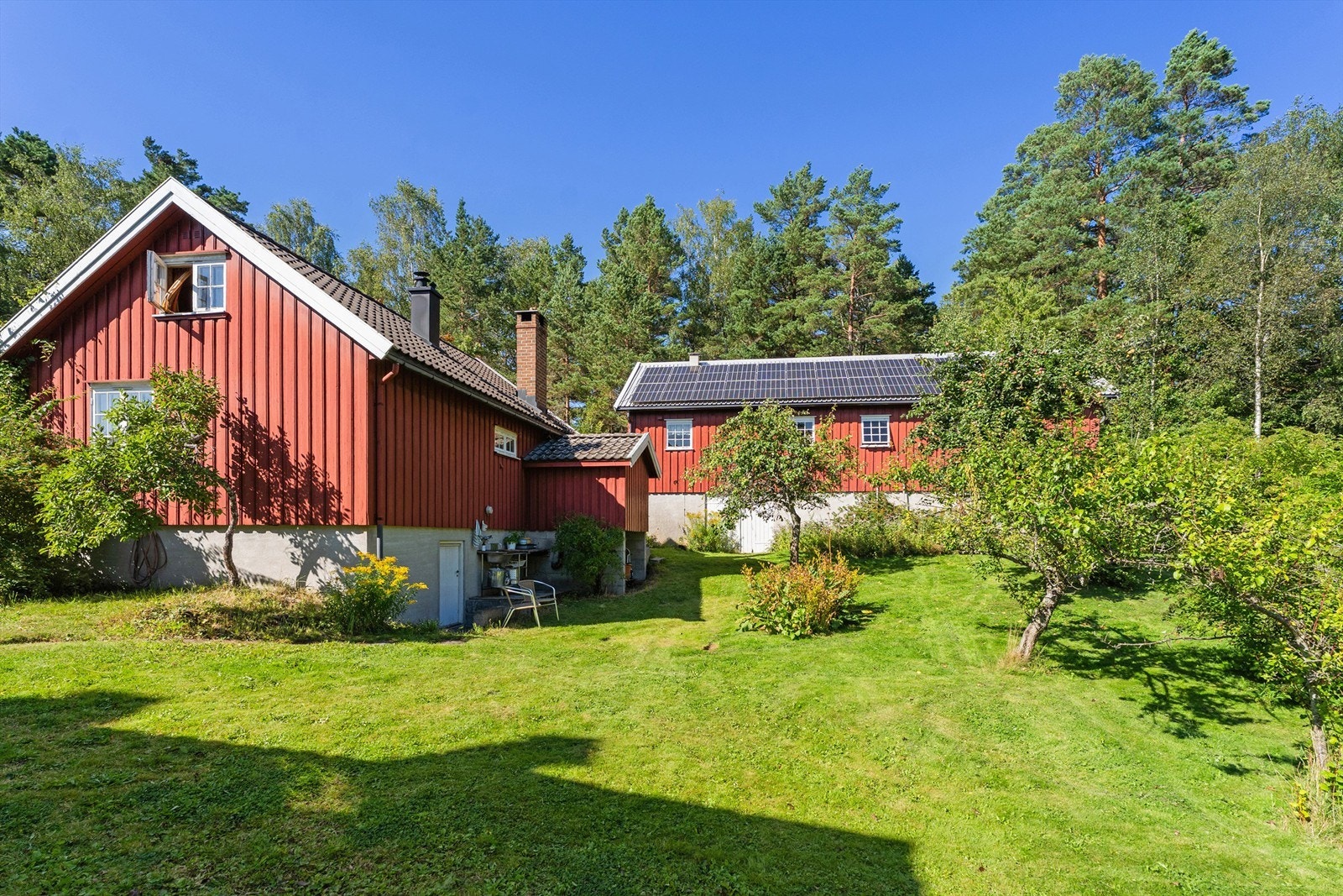Frukthagen. Låve og anneks. Solceller på hele låvetaket. Utekjøkken på veggen til annekset. Galleribilde