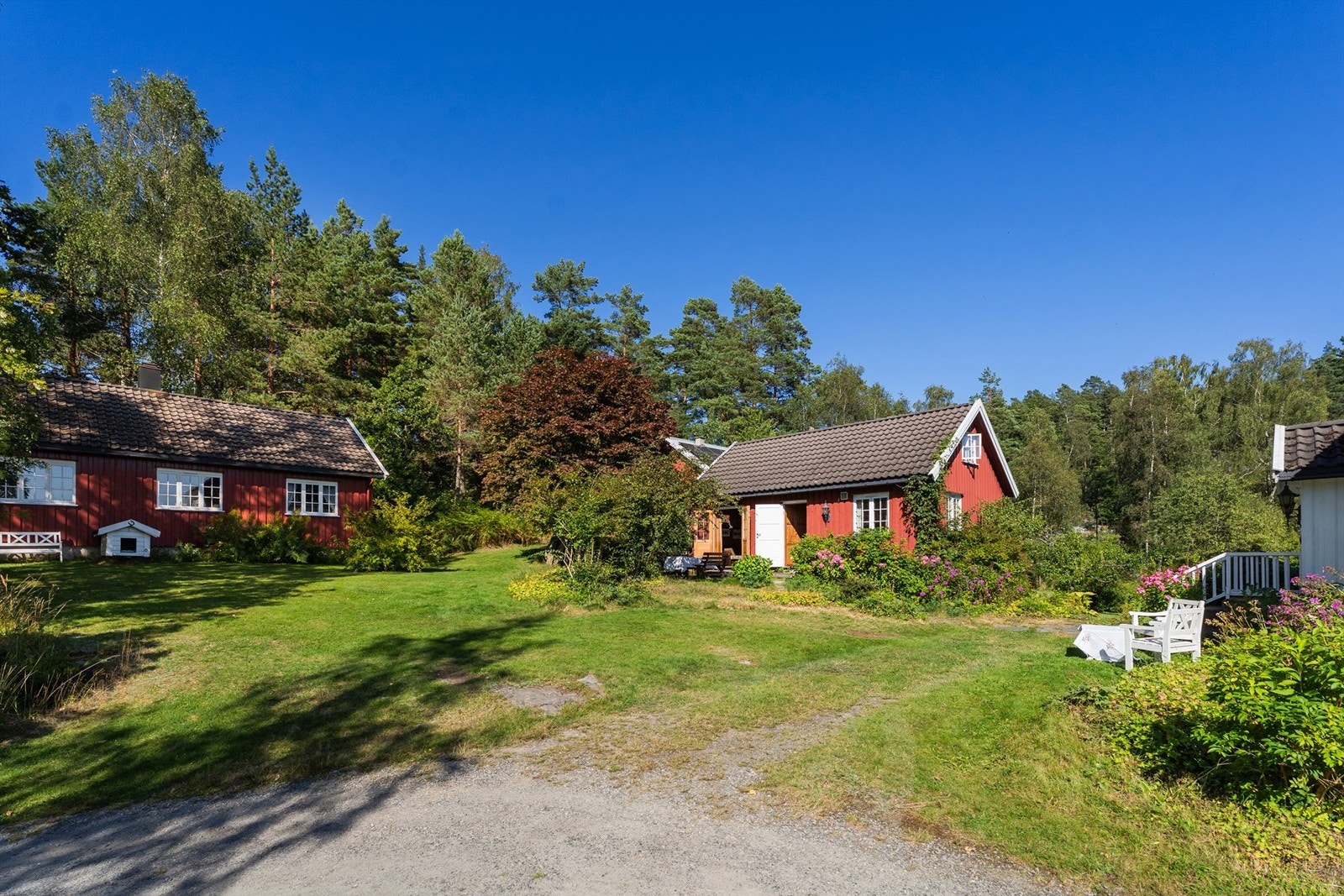 Gjestehuset til venstre, så låven og annekset midt i bildet. Hovedhuset til høyre. Galleribilde