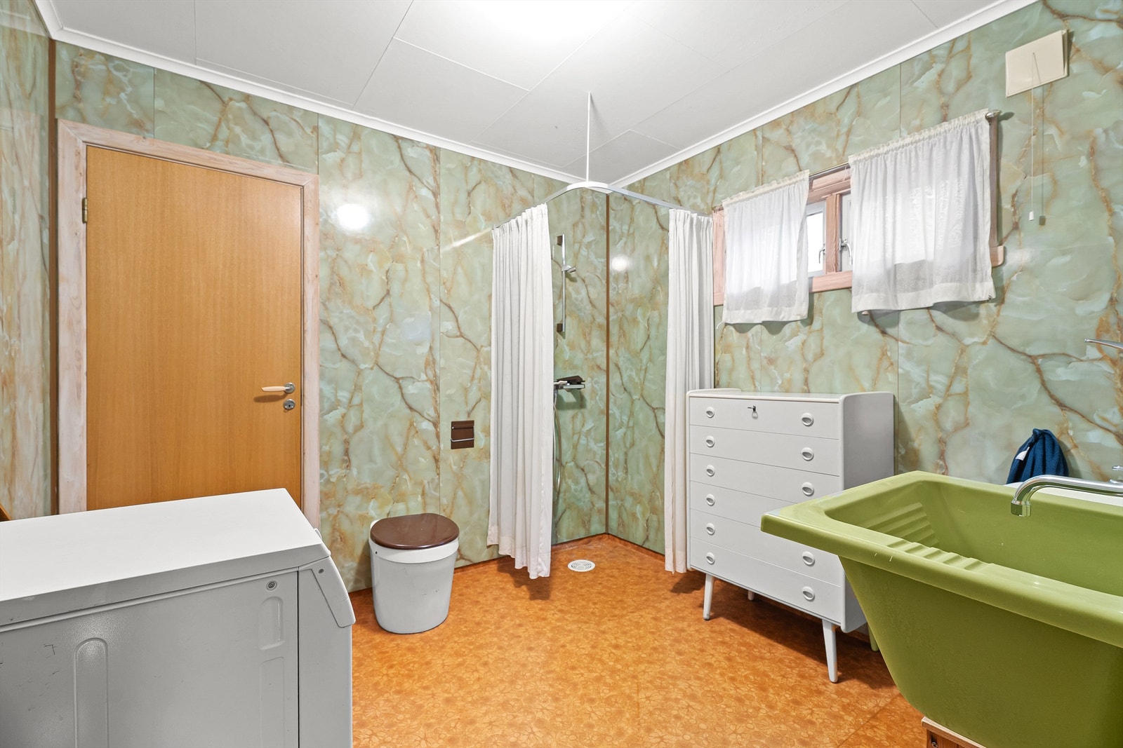 Badet i gjestehuset er innredet med dusjhjørne, servant og opplegg for vaskemaskin. mulldo. Galleribilde