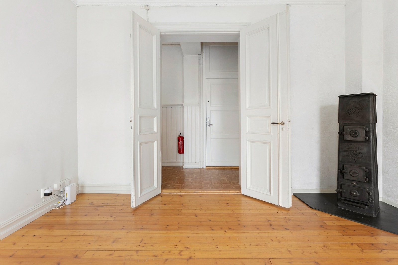 Stuen har fløydører og peis i hjørne. Galleribilde
