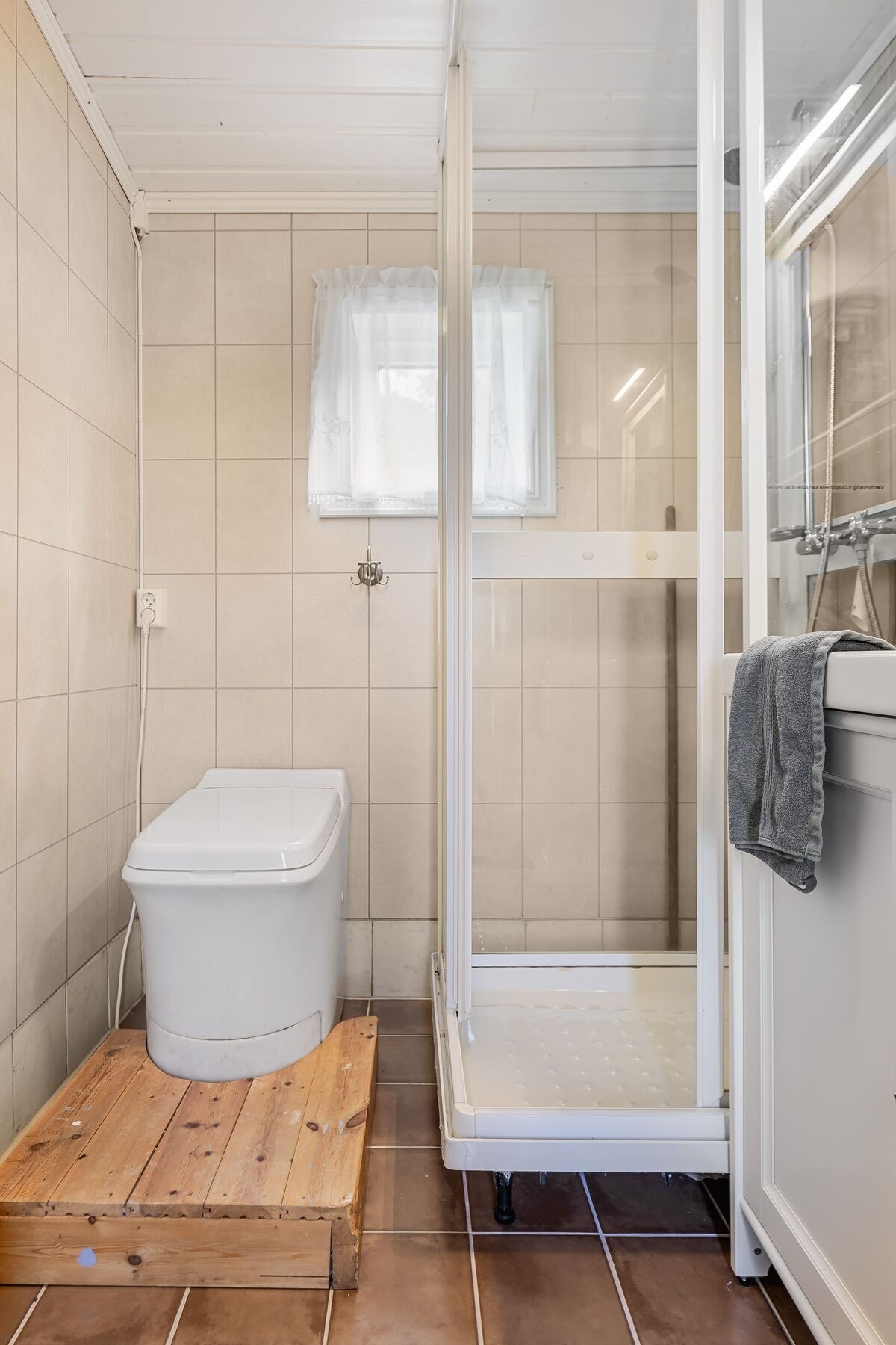 På badet finner man servant i innredning, dusjkabinett og forbrenningstoalett Galleribilde