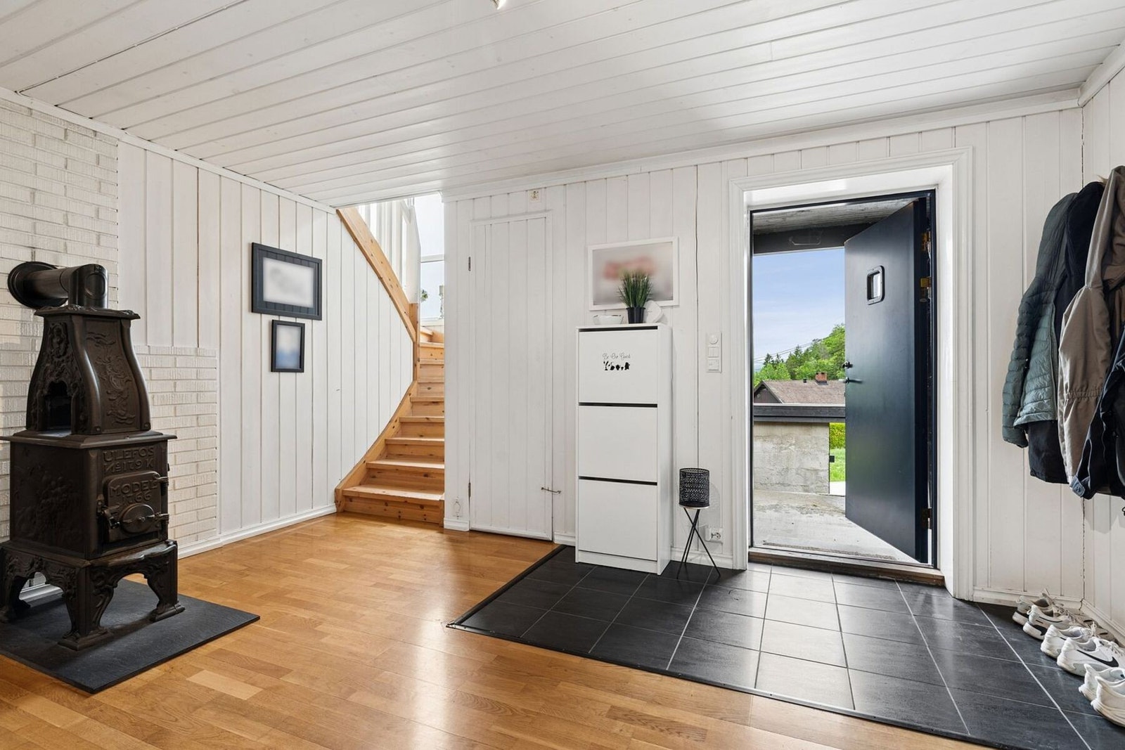 Stor innbydende entré med skyvedørsgarderobe og ovn som gir god varme. Galleribilde