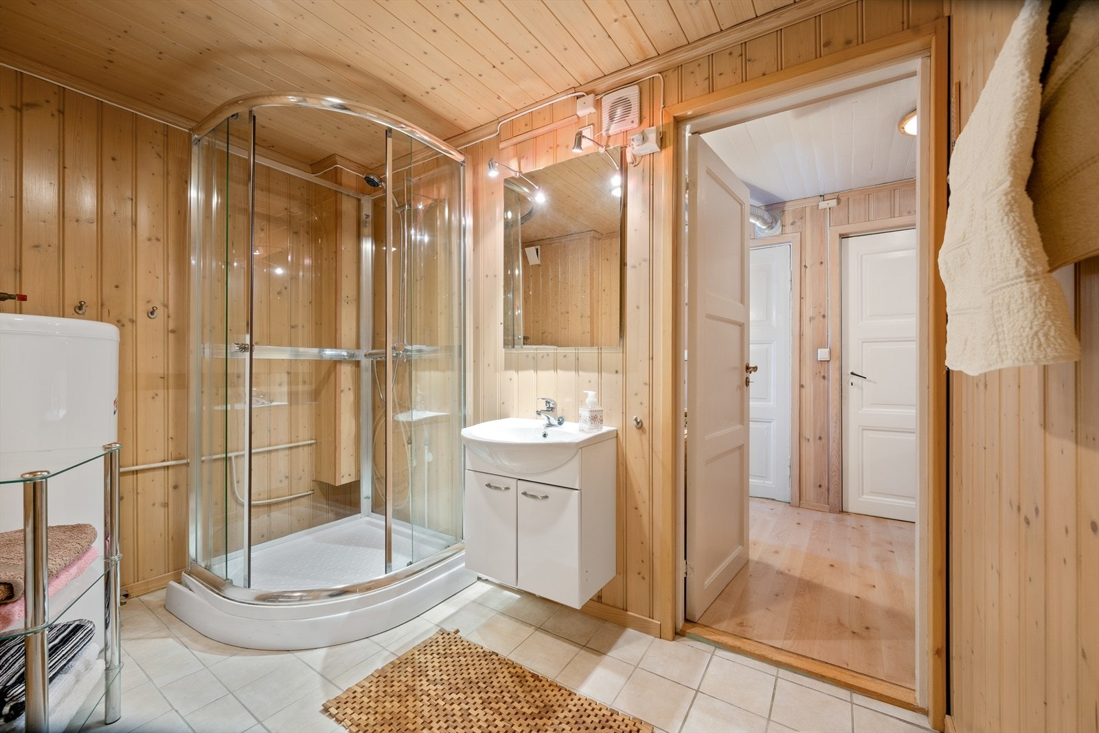 Badet i underetasjen har en harmonisk utforming hvor klassiske elementer møter varme treoverflater, noe som skaper en hjemmekoselig følelse. Galleribilde