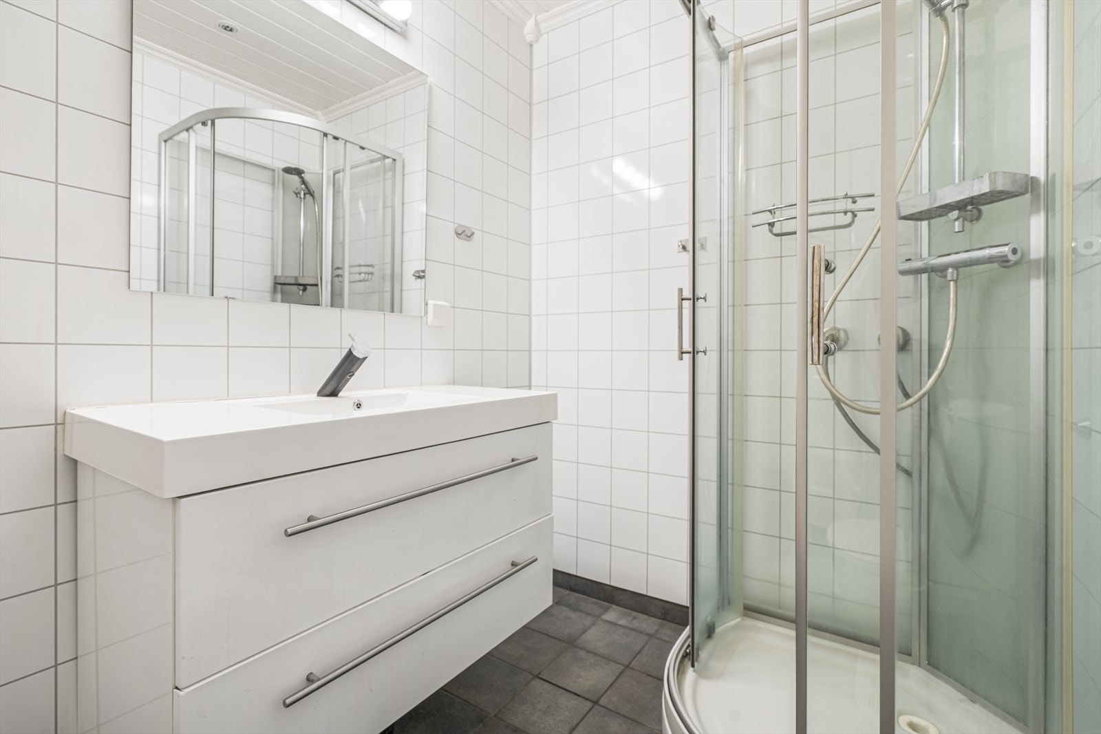 Helfliset baderom med varmekabler og dusjkabinett. Opplegg til vaskemaskin og tørketrommel. Galleribilde