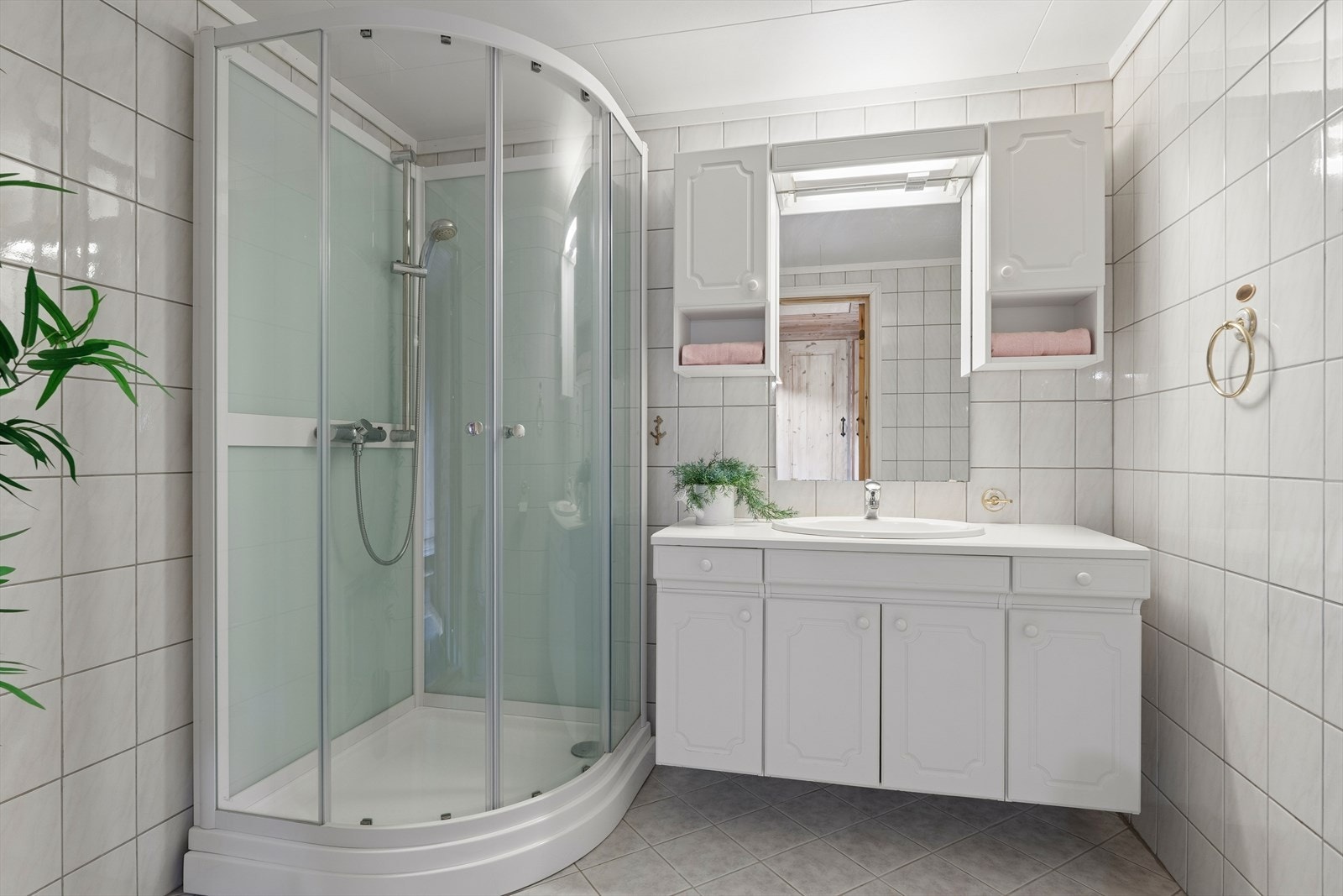 Badet er flislagt og utstyrt med elektriske varmekabler i gulvet, dusjkabinett og opplegg for vaskemaskin. Galleribilde