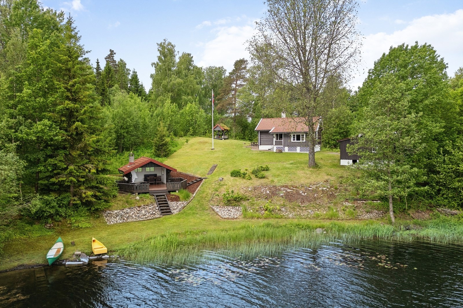 En sjarmerende eiendom med tømmerhytte, anneks og garasje, beliggende på en stor tomt som skråner ned mot Illestadvannet. Galleribilde