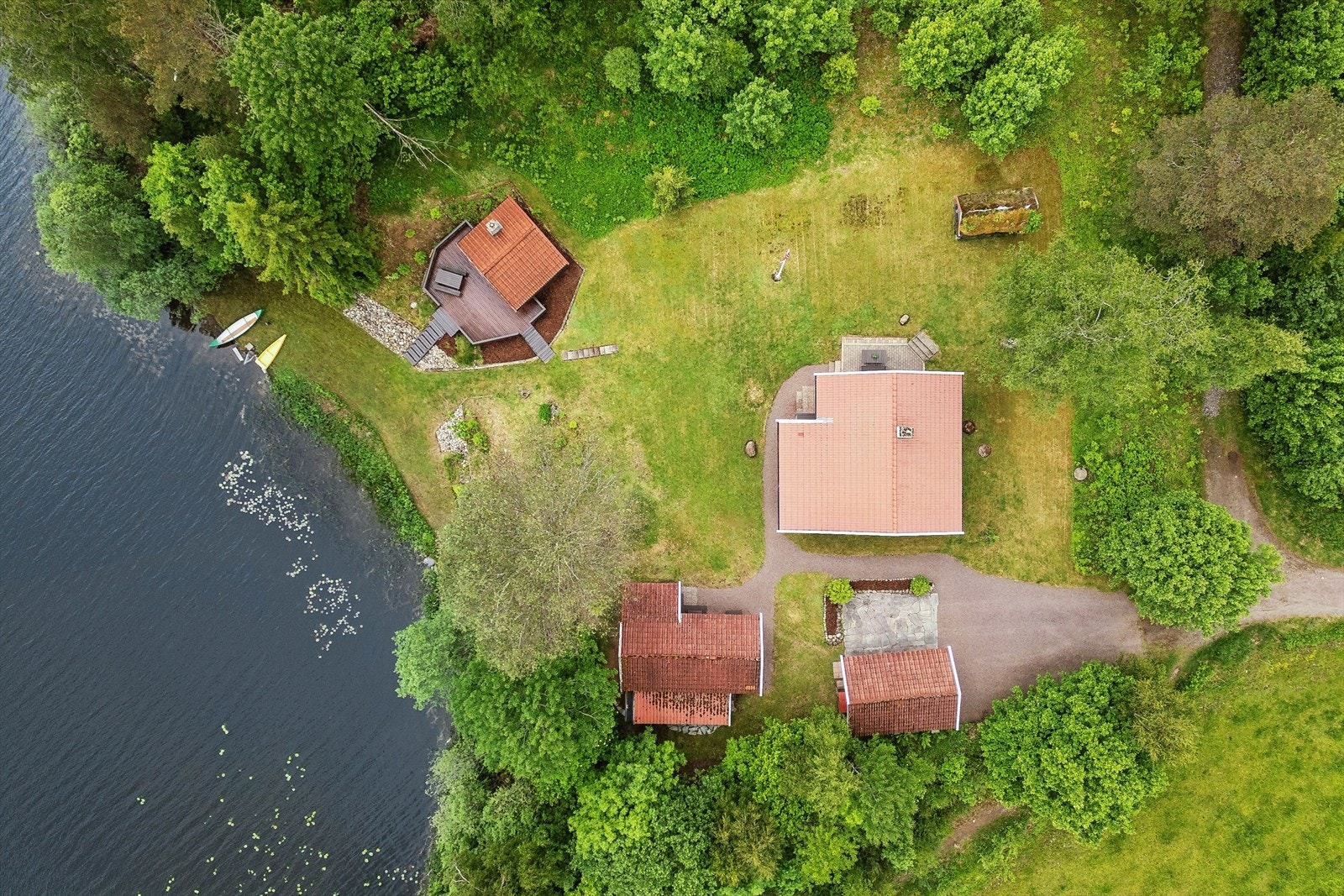 Eiendommen har en oversiktlig plassering av bygningsmassen, med utestuen som et eget fristed nede ved vannet. Galleribilde