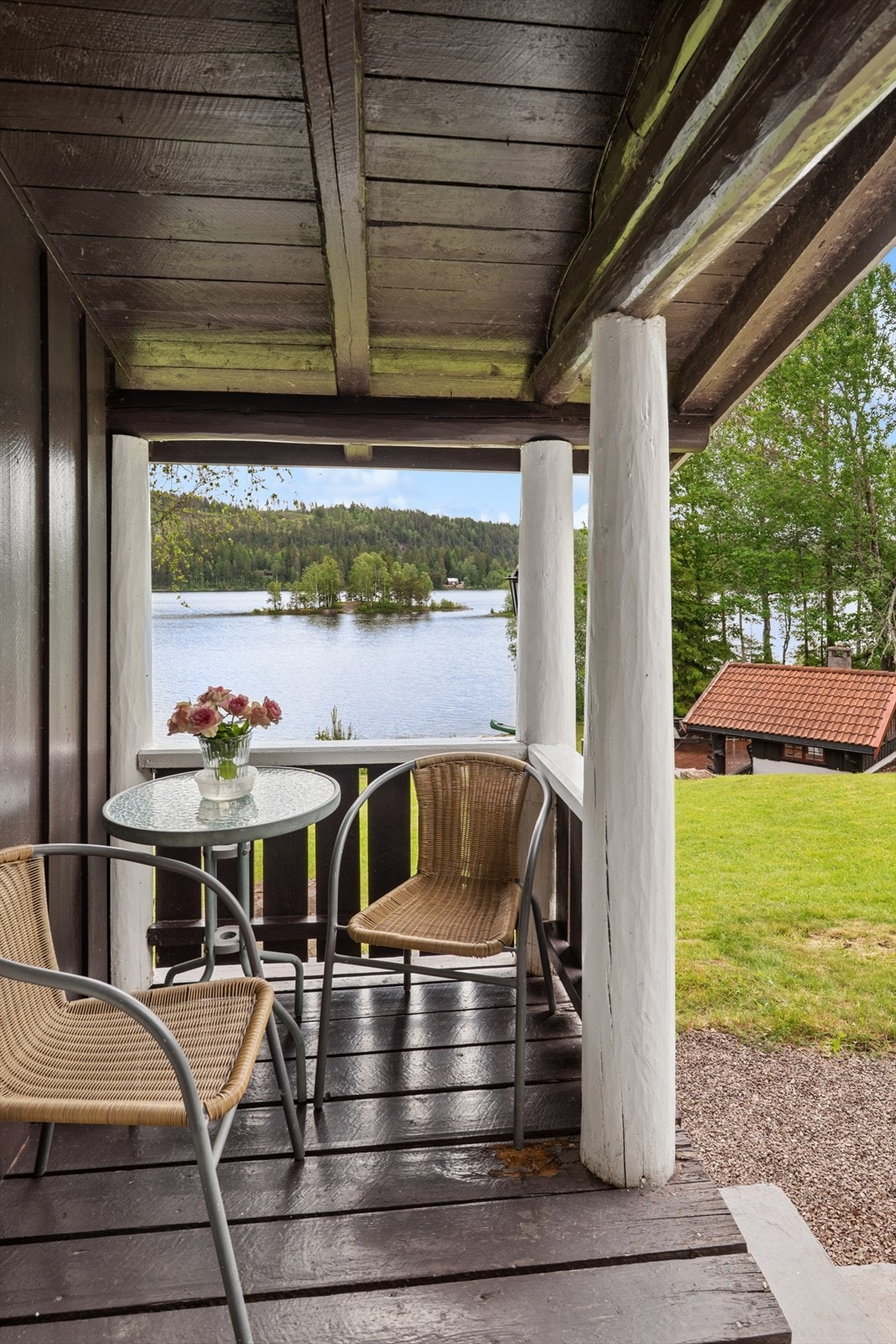 En liten, overbygget veranda gir en lun uteplass med utsikt mot vannet. Galleribilde