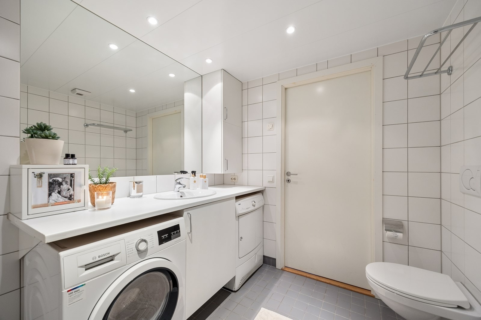 Badet er innredet med servantinnredning med god oppbevaringsplass, speil, vegghengt toalett og dusjløsning med glassvegger Galleribilde