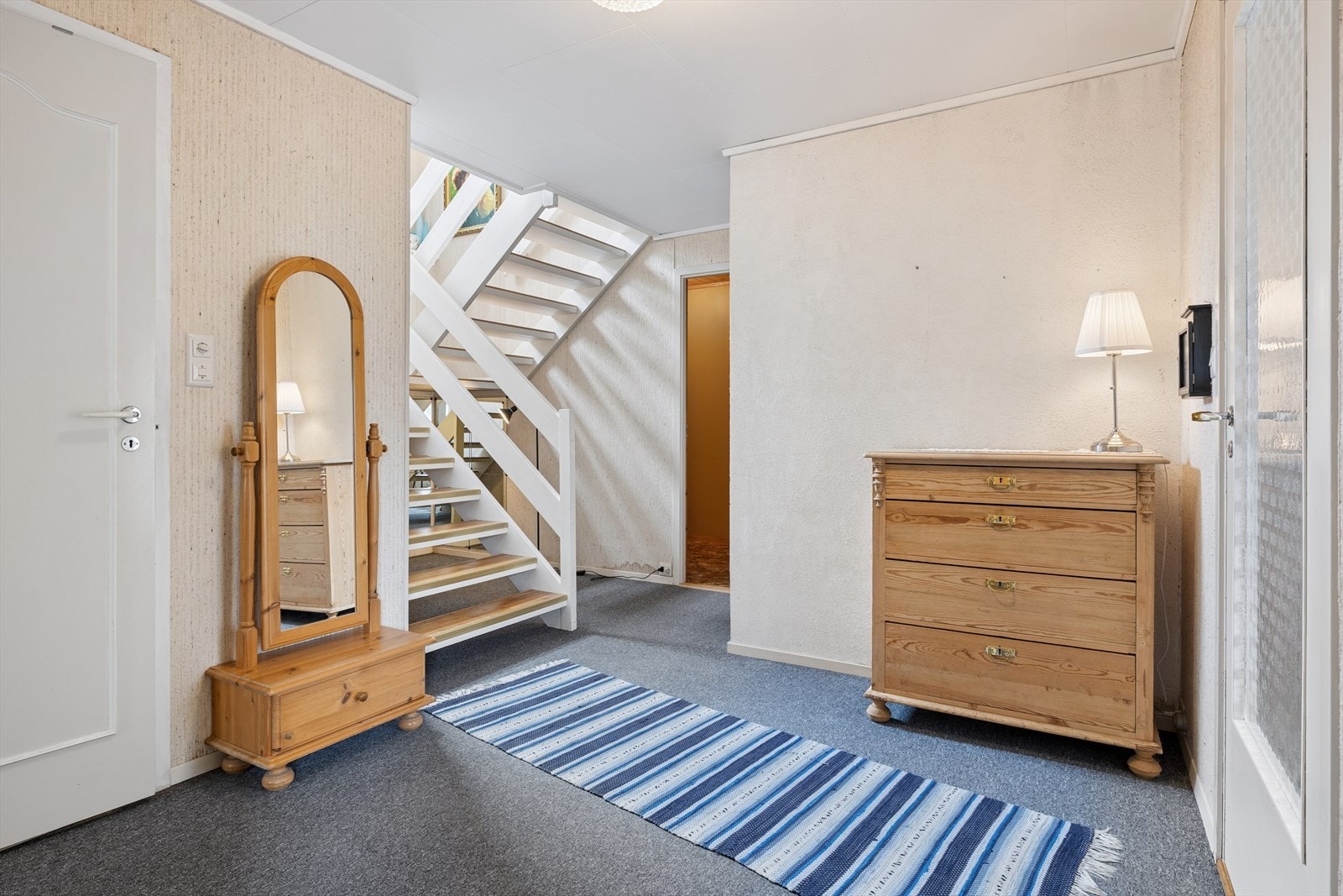 Fra vindfanget kommer du inn i gangen med trappeadkomst opp til hovedplanet. Teppebelagt gulv. Galleribilde