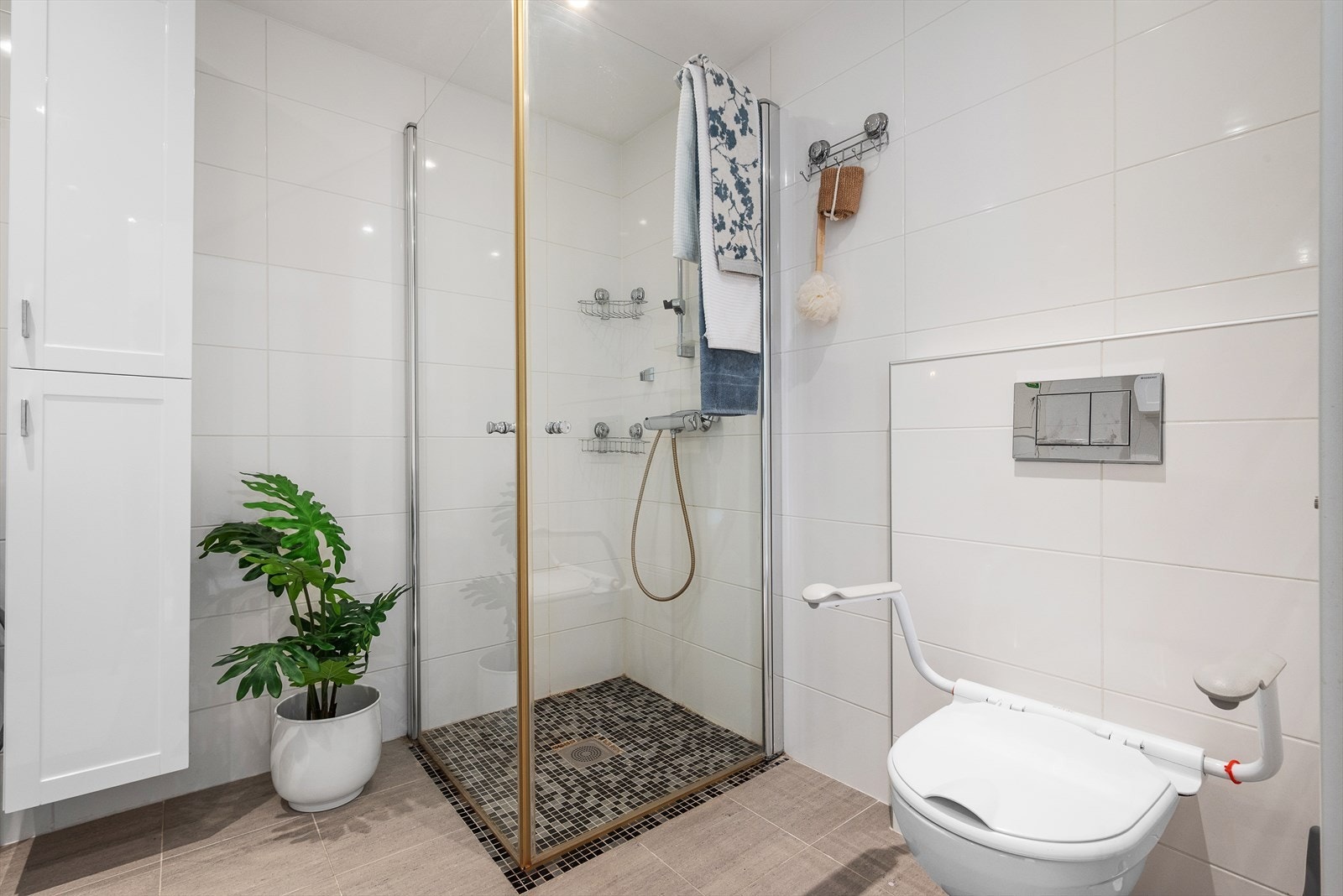 Badet har lekre detaljer, og er utstyrt med wc, servant og dusj, innfellbare glassdører og opplegg for vaskemaskin. Galleribilde