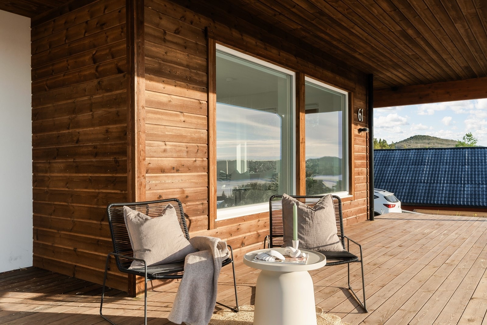 Boligen fremstår godt plassert i terrenget, med en moderne fasade som harmonerer fint med omgivelsene. Galleribilde
