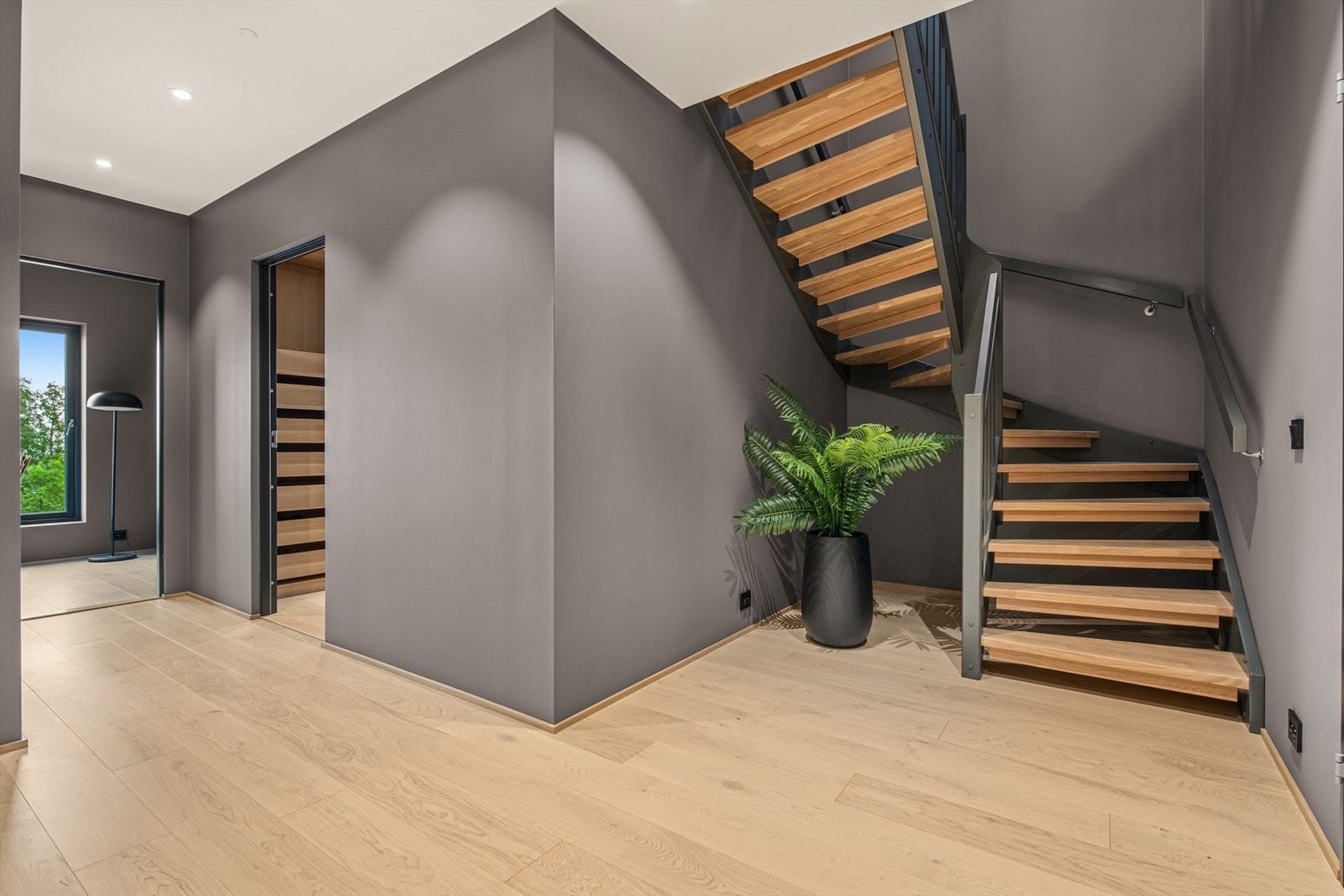 Gangen binder sammen rommene i underetasjen. Trappen i treverk leder opp til hovedetasjen. Galleribilde