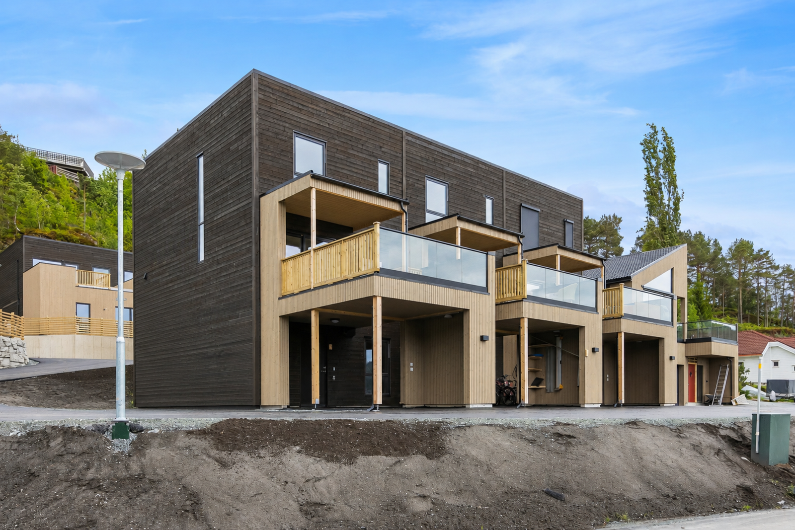 Fasade av boligen. Det gjøres oppmerksom på at uteområde er redigert med AI. det er noen avvik i terrenget på siden av boligen. Galleribilde