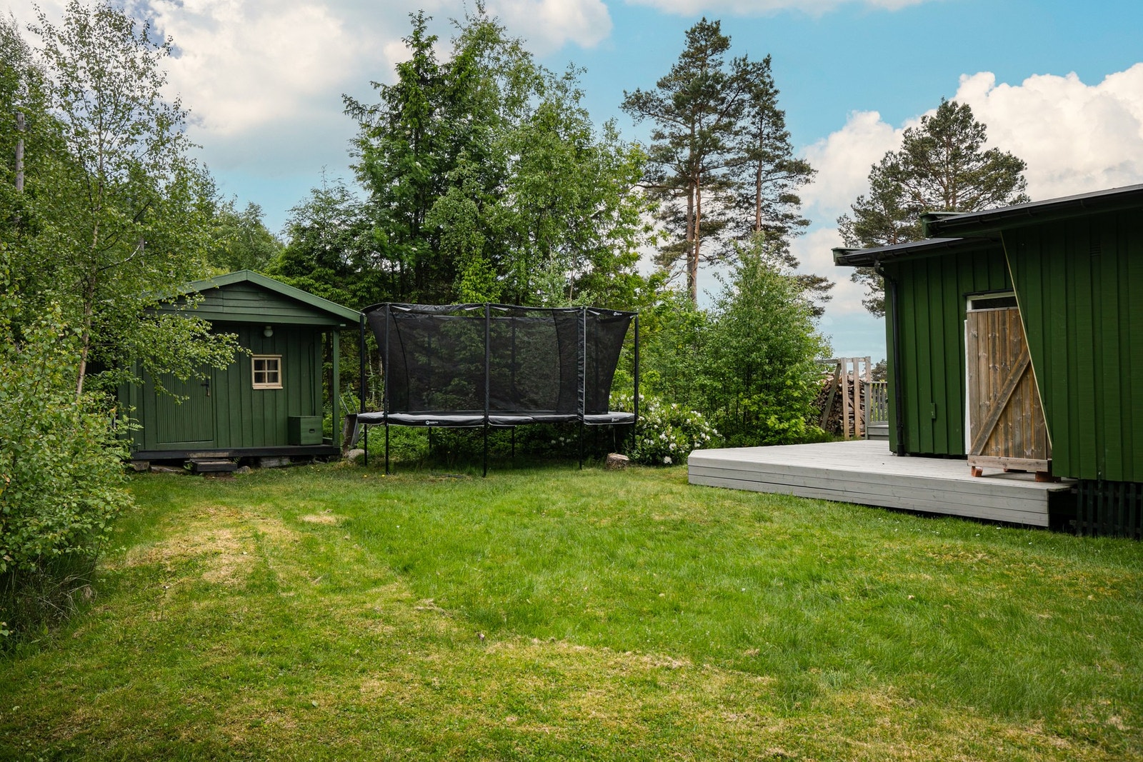 Koselig hage på baksiden av eiendommen. Frittstående bod med plass til oppbevaring. Galleribilde
