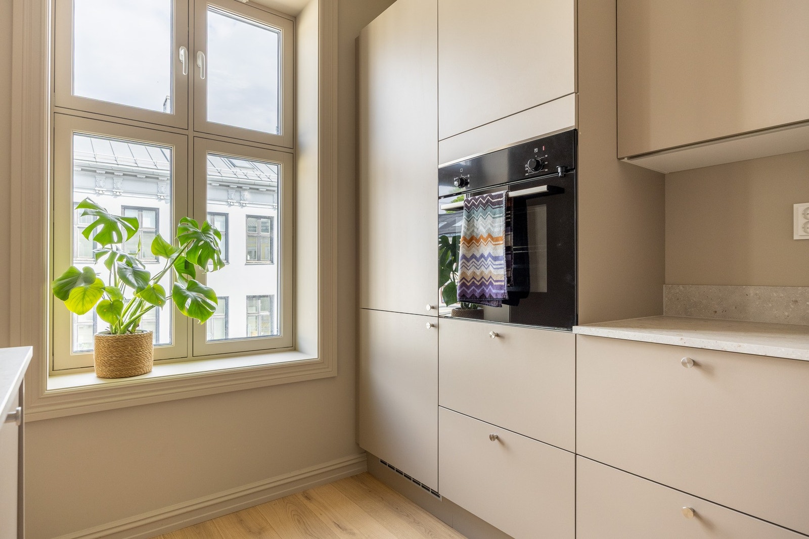 Lekkert HTH kjøkken fra 2024 med glatte fronter og benkeplate i laminat. Galleribilde