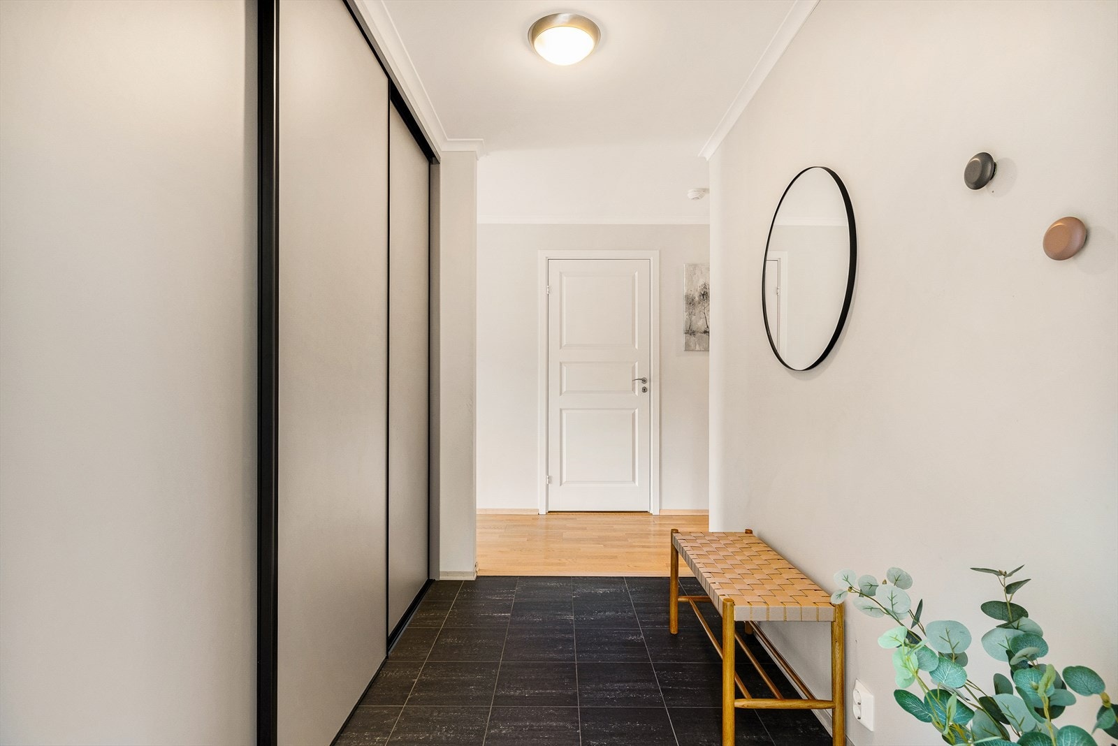 Entréen gir et svært godt førsteinntrykk av boligen med lyse overflater og en innbydende atmosfære. Rommet fremstår som både praktisk og romslig, med god plass til å ta imot gjester og håndtere hverdagens behov. Galleribilde