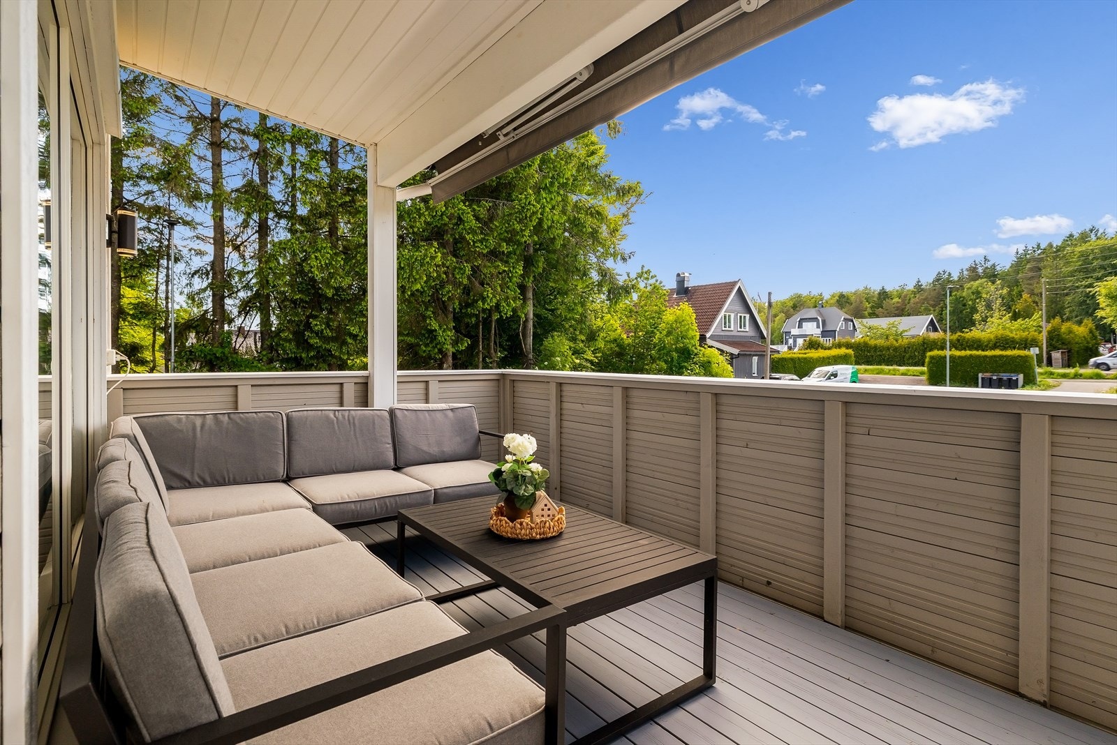 Balkongen fremstår som et hyggelig og innbydende uteområde med gulv belagt med malte og impregnerte terrassebord, som gir et pent uttrykk og krever minimalt med vedlikehold. Galleribilde