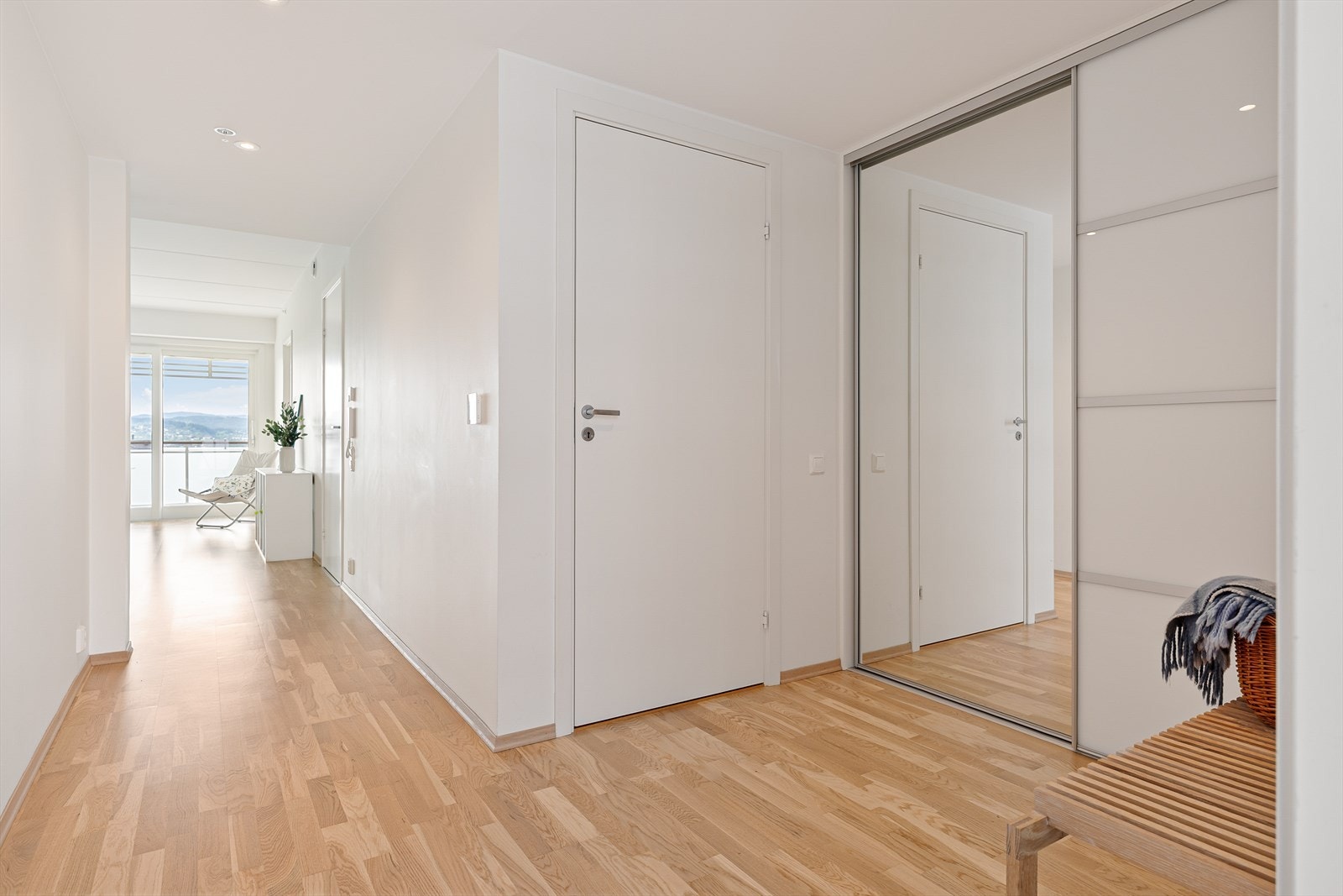 Romslig gang med skyvedørsgarderobe og inngang til en praktisk bod. Galleribilde