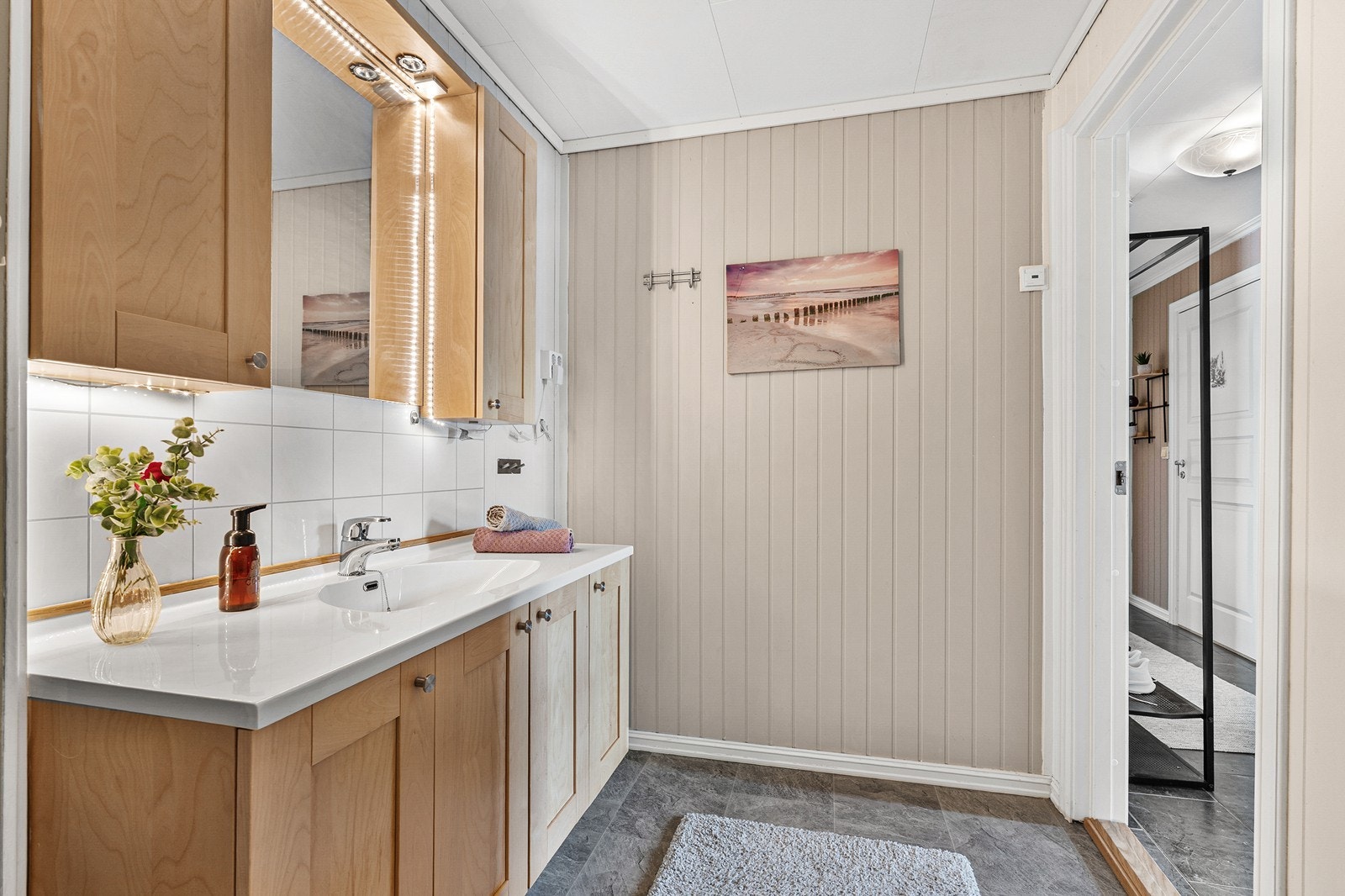Badet er innredet med dusjhjørne, toalett og baderomsinnredning med nedfelt servant. Galleribilde