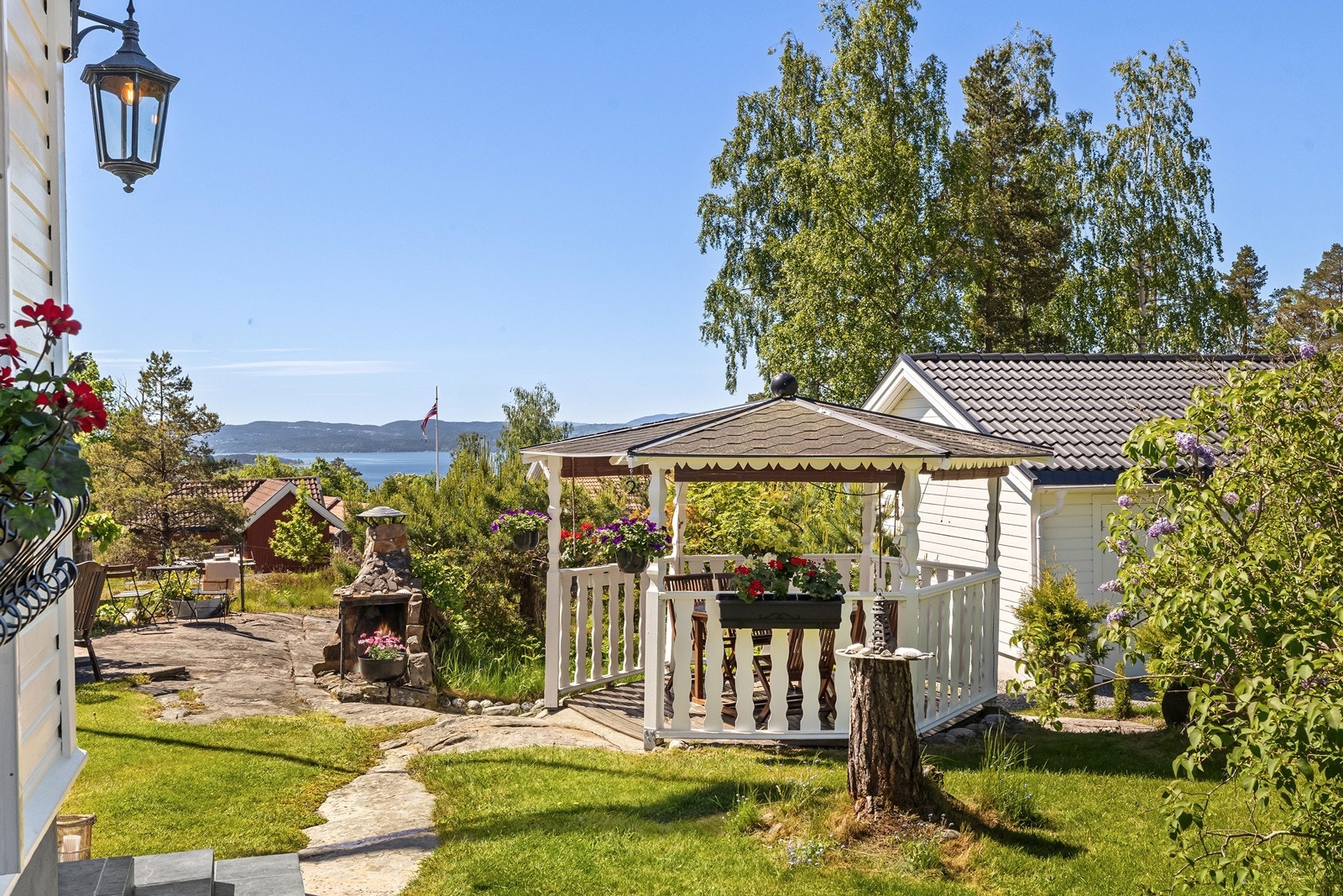 Her er et idyllisk lysthus som gir en "ekstra stue" i hagen og en stemningsfull ramme for både sosialt og alenetid. Galleribilde