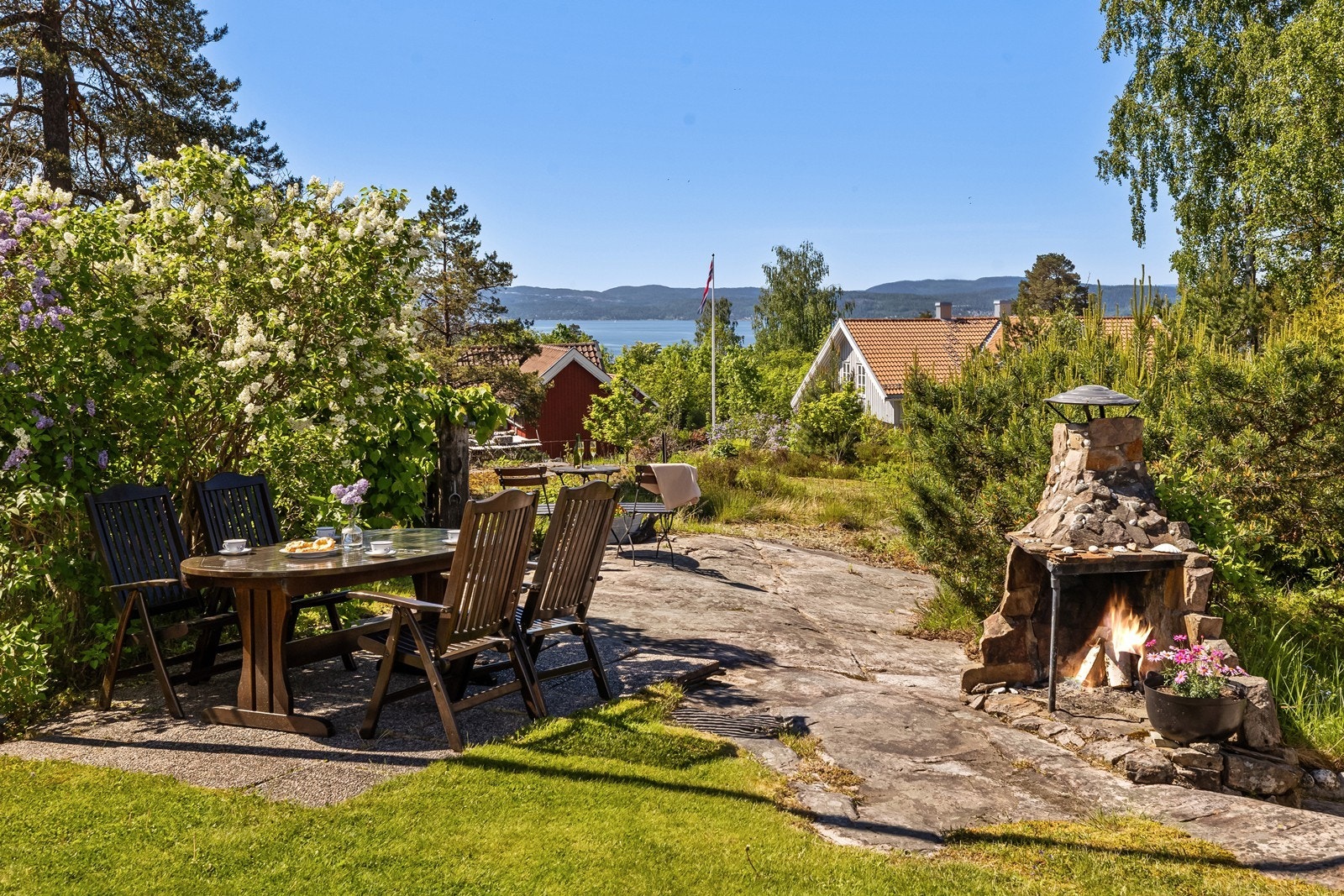 Et hyggelig og lunt område med murt utepeis - plasser spiseplassen eller en lounge her for sene utekvelder til peisknitring. Galleribilde
