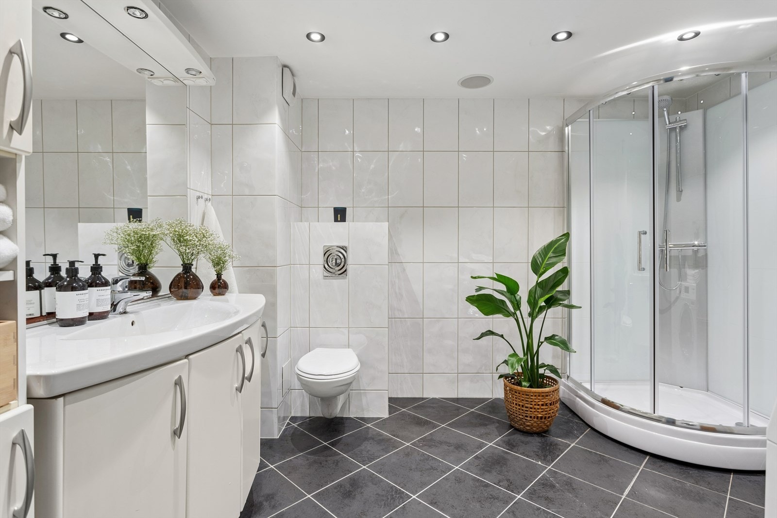 Badet er innredet med vegghengt toalett, servant med underskap og speil. I tillegg ble det installert nytt dusjkabinett i 2026. Galleribilde
