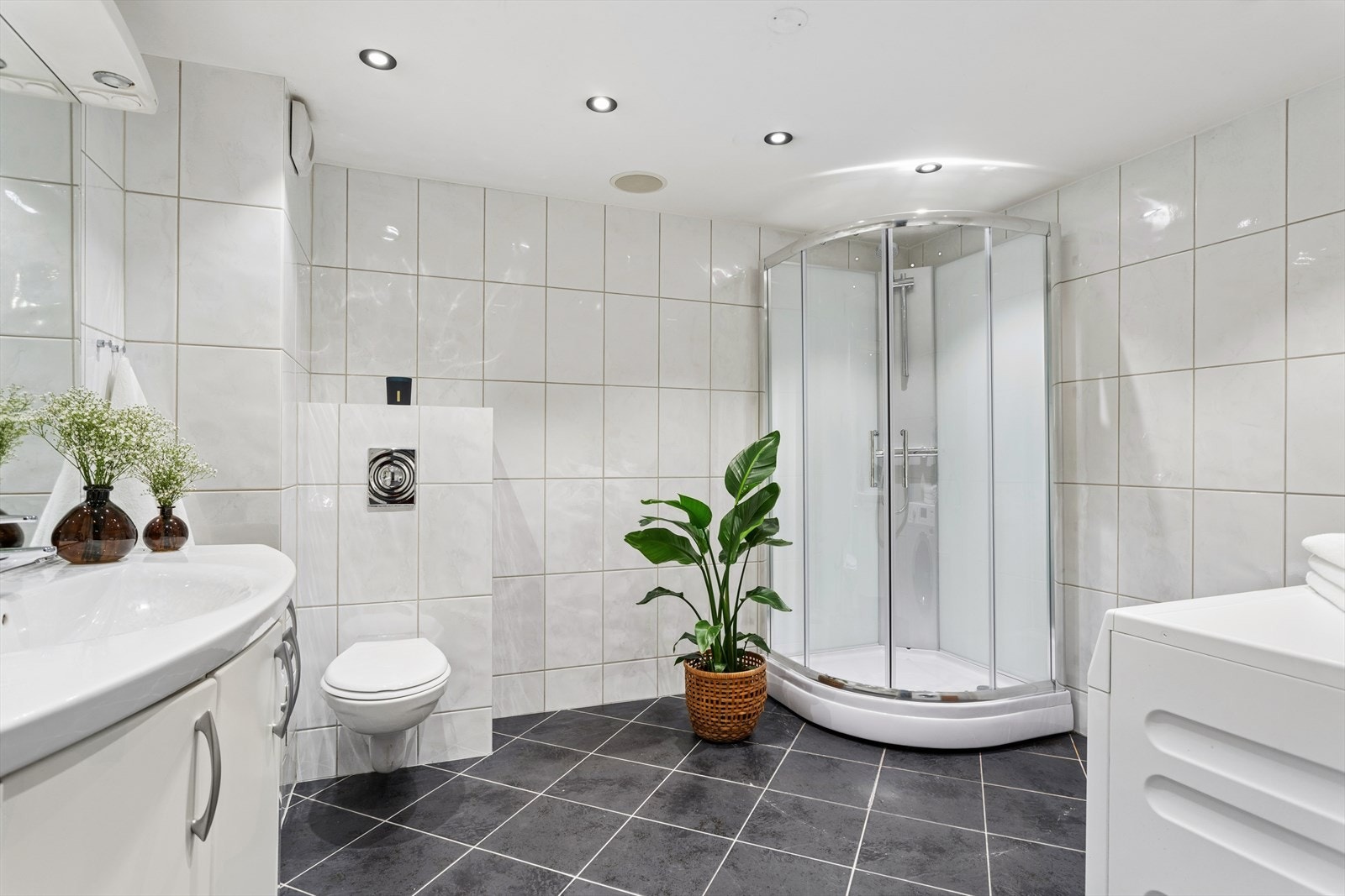 Badet er lyst og romslig med flislagte vegger og gulv. Galleribilde
