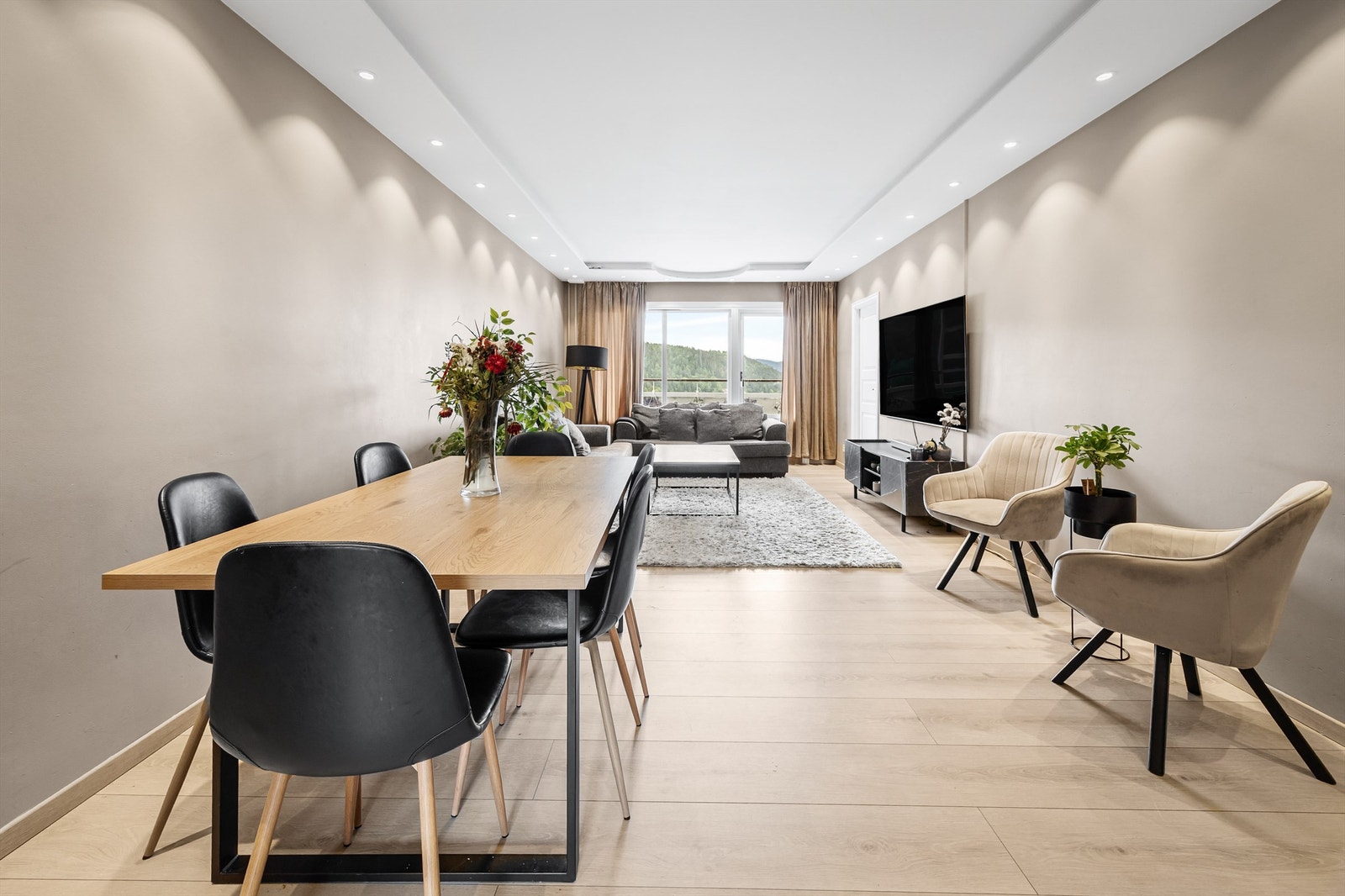 Lys og lun stue med sofaområde, sittegruppe samt spiseplass. Galleribilde