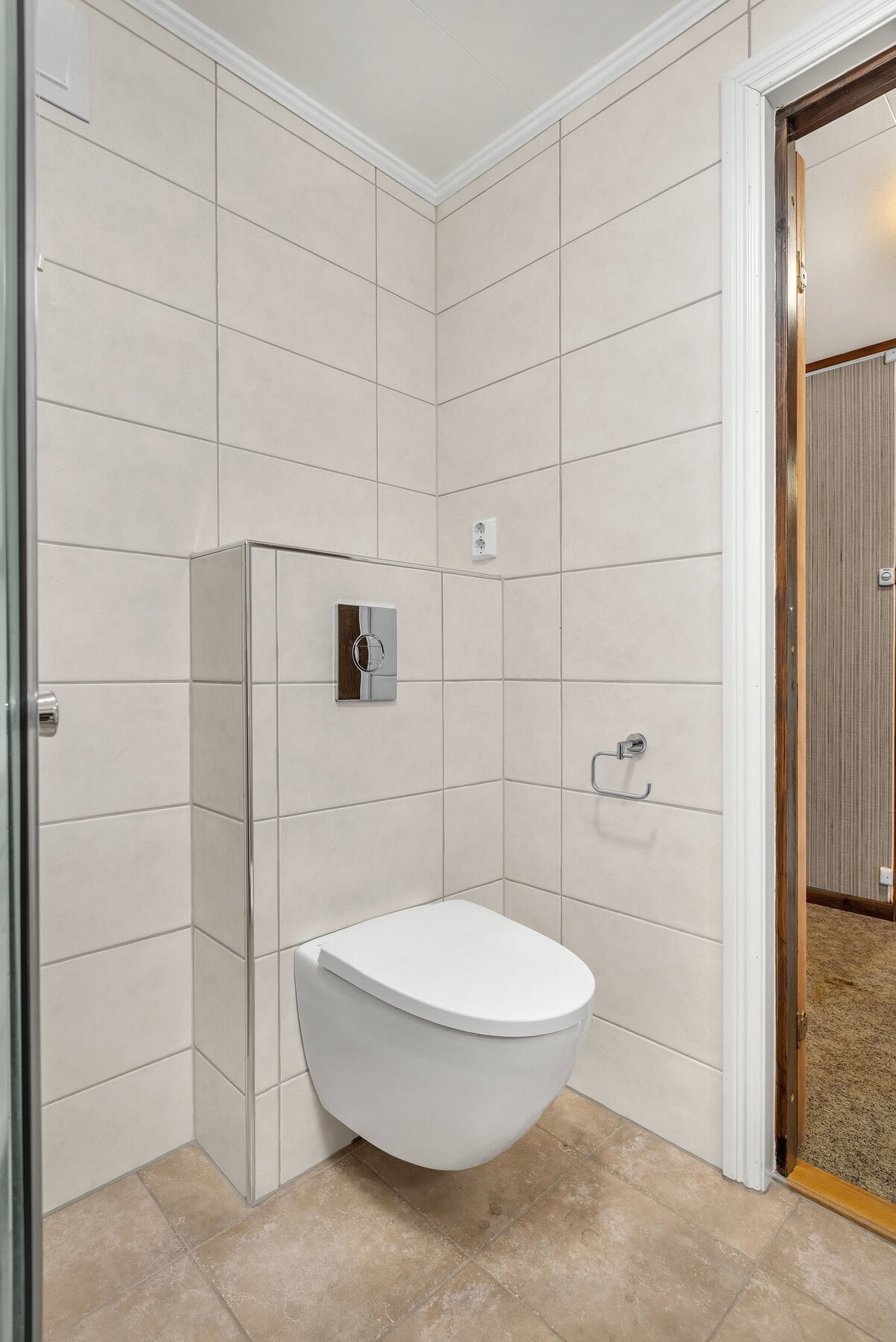 Badet er utstyrt med veggmontert toalett og dusjhjørne med innfellbare glassdører. Galleribilde