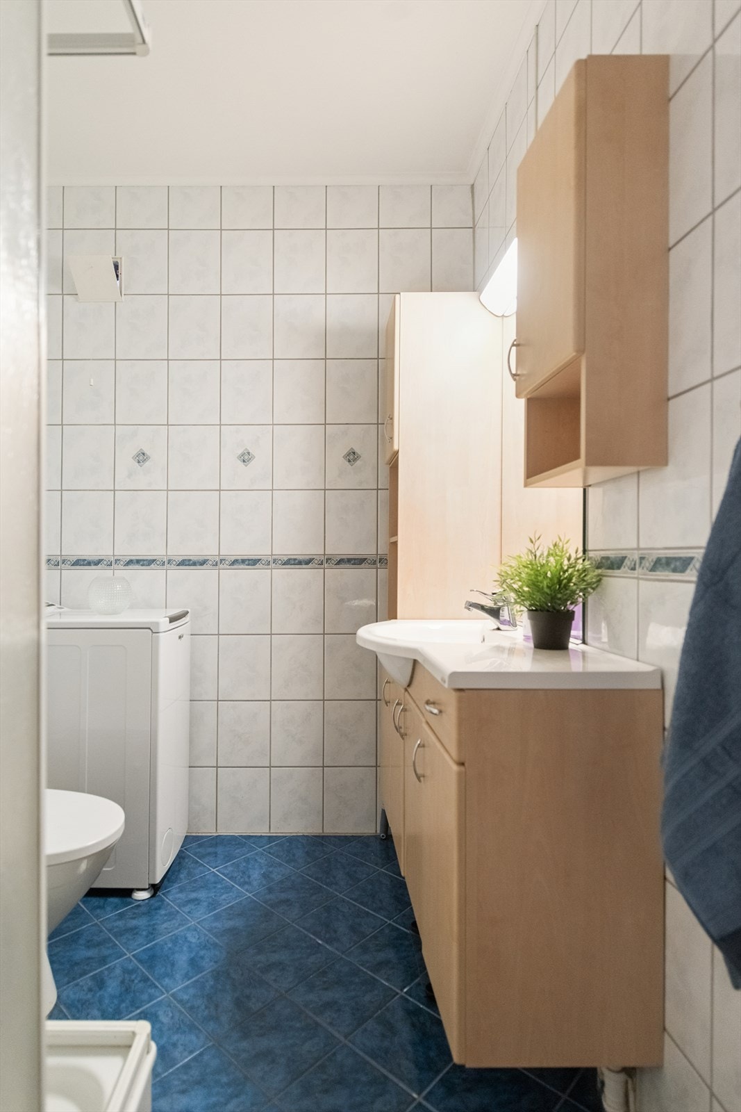 Flislagt bad med gulvvarme og opplegg for vaskemaskin. Galleribilde