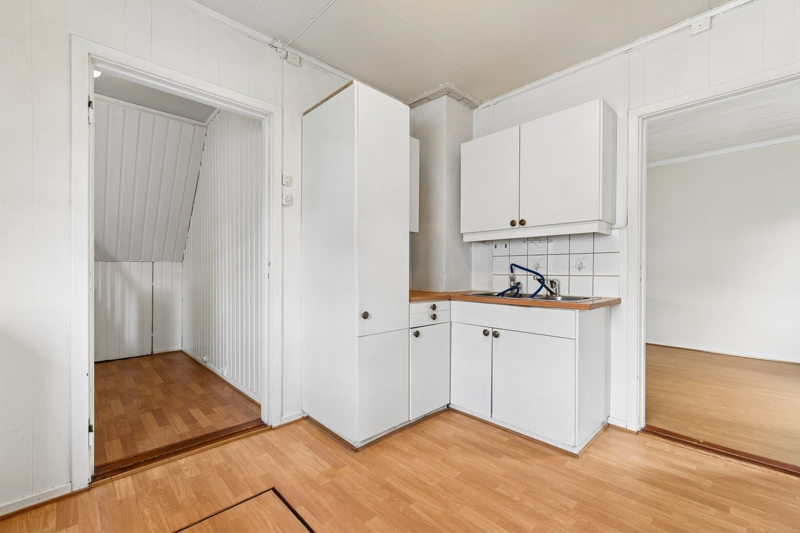 Kjøkkeninnredning med glatte fronter, laminert benkeplate og plass til frittstående hvitevarer. Galleribilde