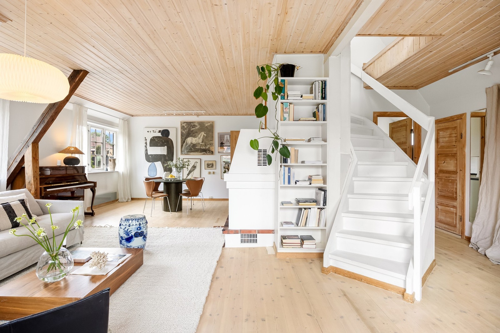 Fra hovedetasjen leder trappen videre opp til loftsetasjen, hvor boligen åpner seg opp med en luftig og særpreget romfølelse. Galleribilde
