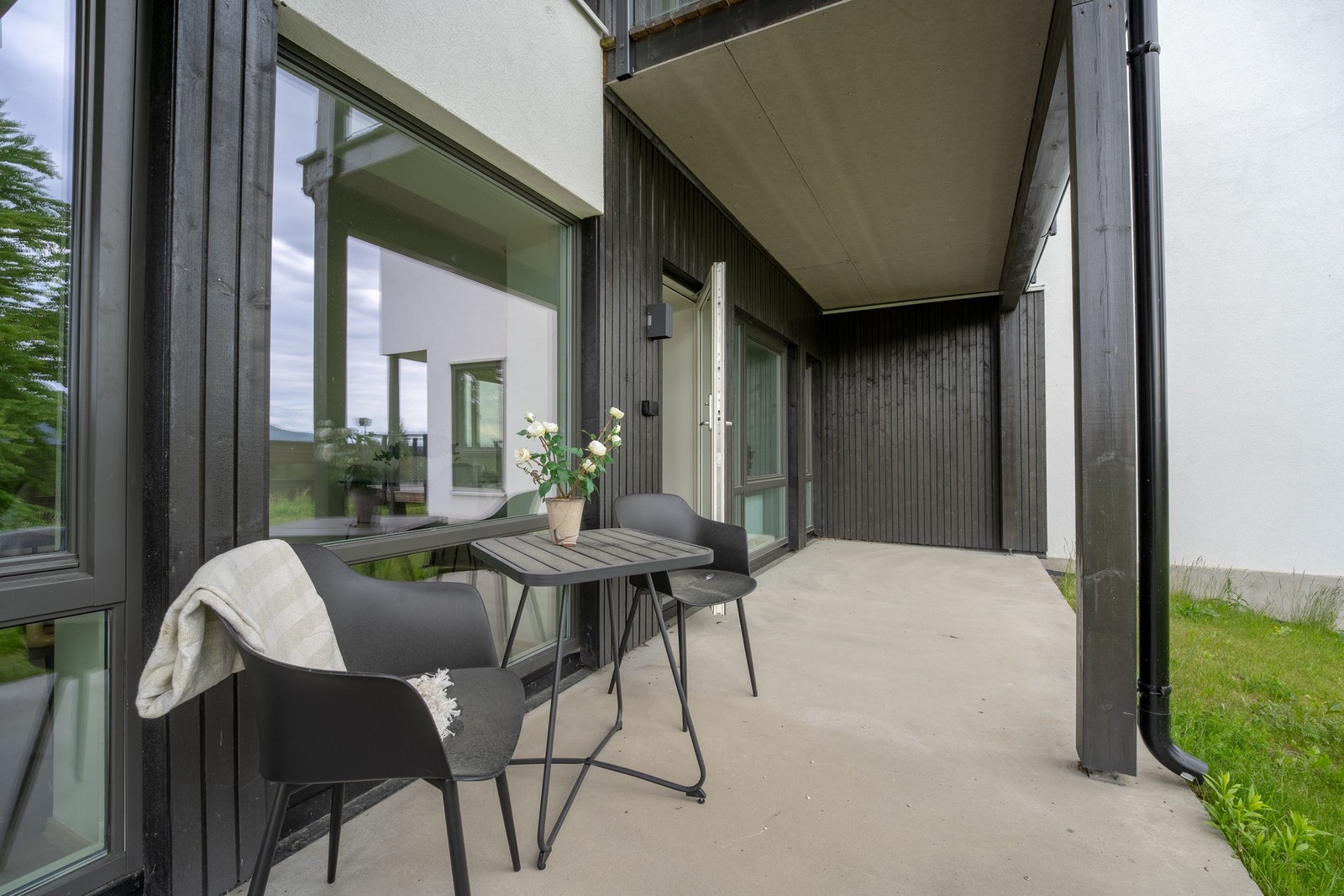 Fra stuen er det direkte utgang til en romslig terrasse på bakkenivå, belagt med betongdekke og godt egnet for både sittegruppe, grill og blomsterkasser. Galleribilde