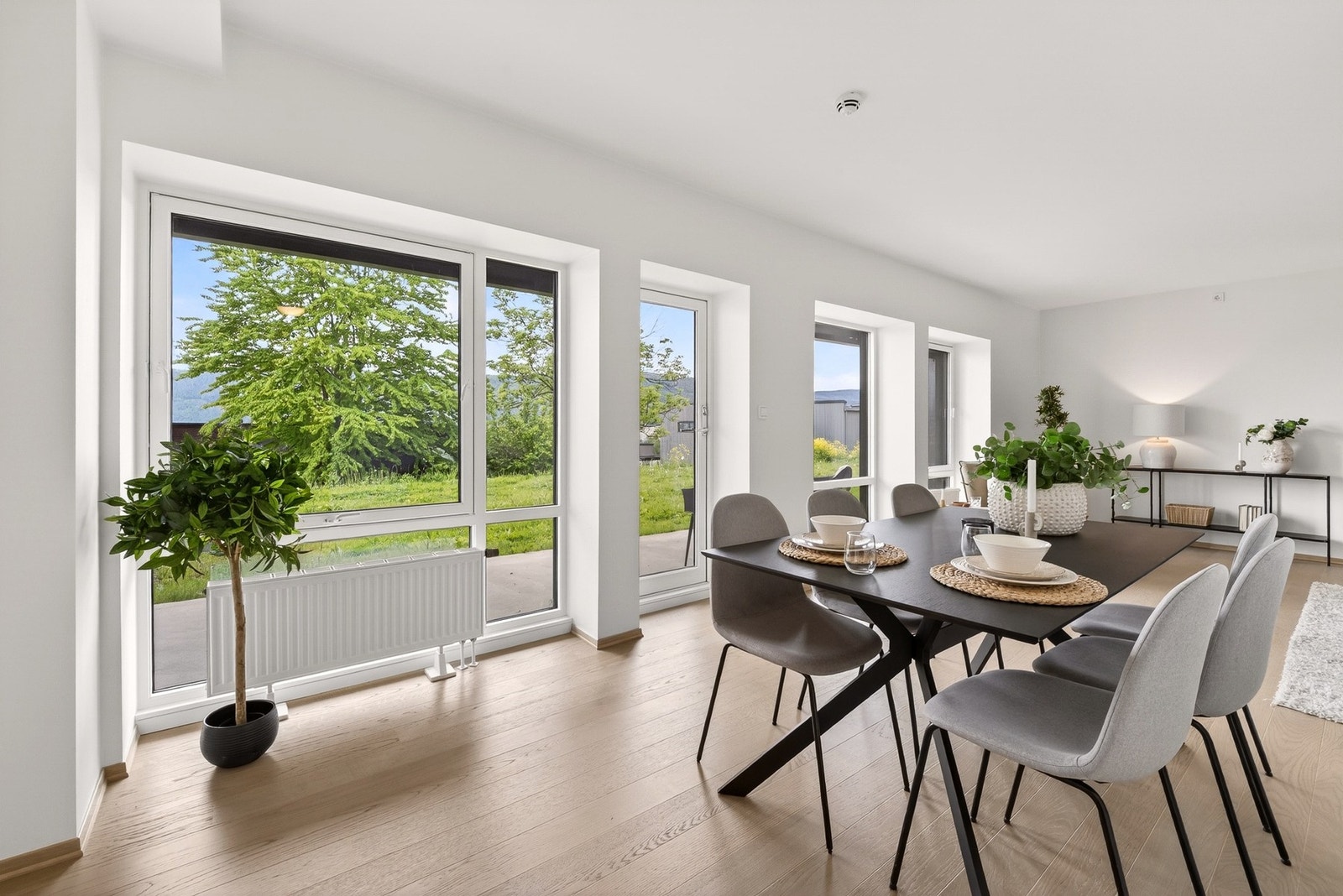 Rommet har en naturlig inndeling mellom sofagruppe og spiseplass, noe som gjør det enkelt å skape hyggelige soner. Galleribilde