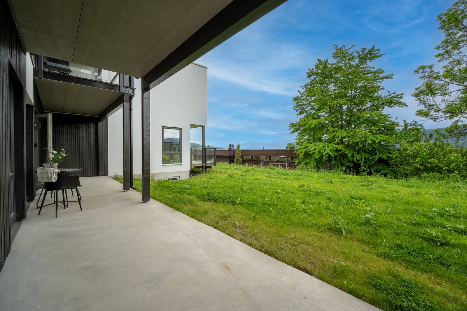 Her kan du nyte lange sommerdager med sol og utsyn mot grøntarealer som skaper en åpen og luftig atmosfære. Galleribilde