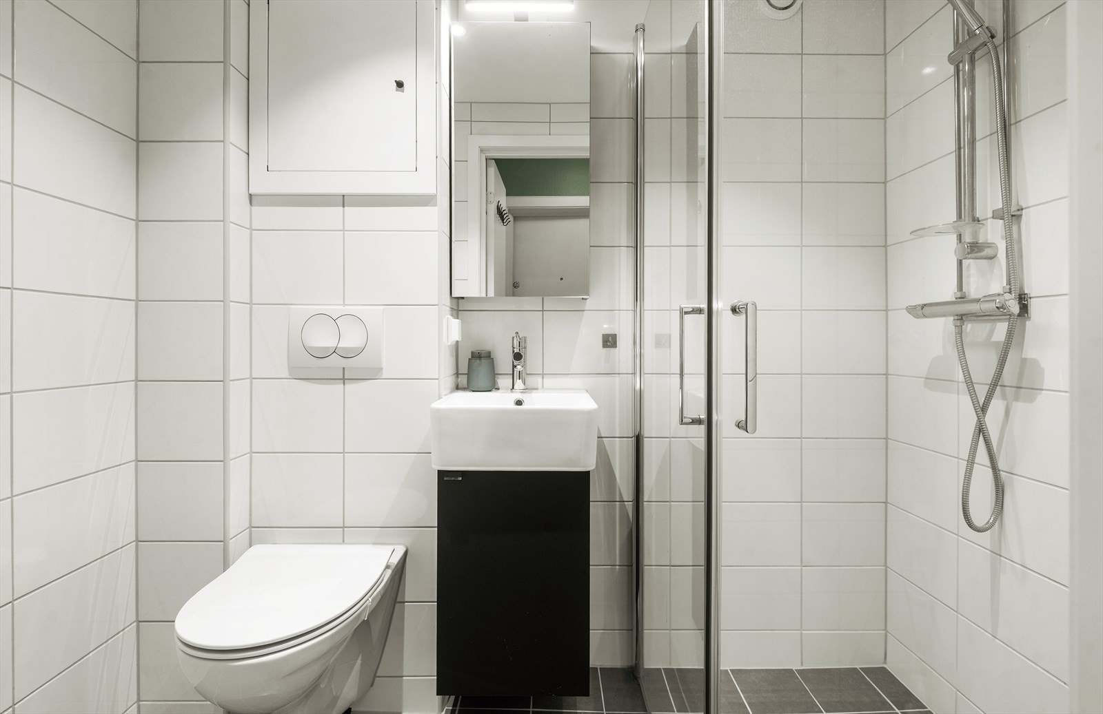 Badet har flislagte overflater, varmekabler i gulvet og opplegg for vaskemaskin. Badet ble pusset opp av SANS Bygg AS i 2024. Galleribilde