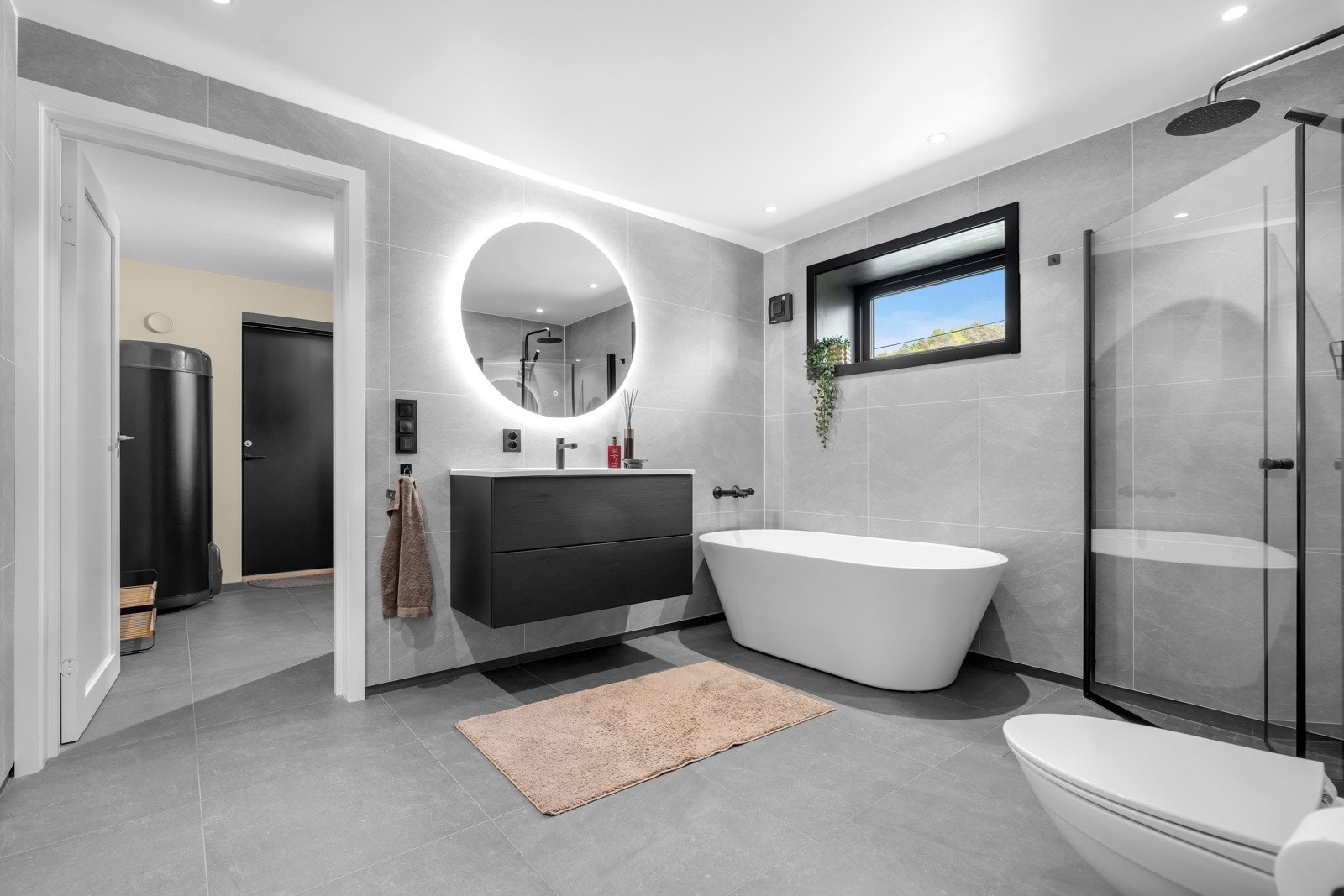 Badet i 1.etasje er stilfullt med 60*60 flis på gulvet, sort innredning og badekar. Rommet er tidl. bod (ikke byggemeldt bruksendringen). Galleribilde