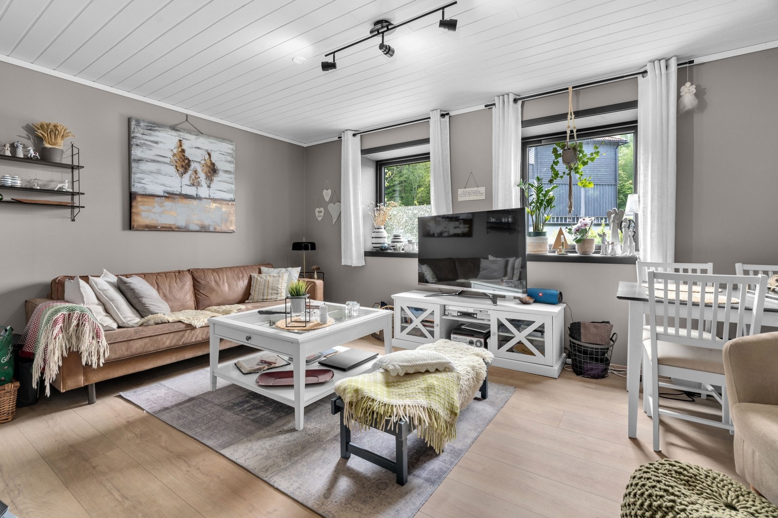 Romslig og lys stue som har laminat med varmekabler på gulvet og Walls to paint plater på veggene. Galleribilde