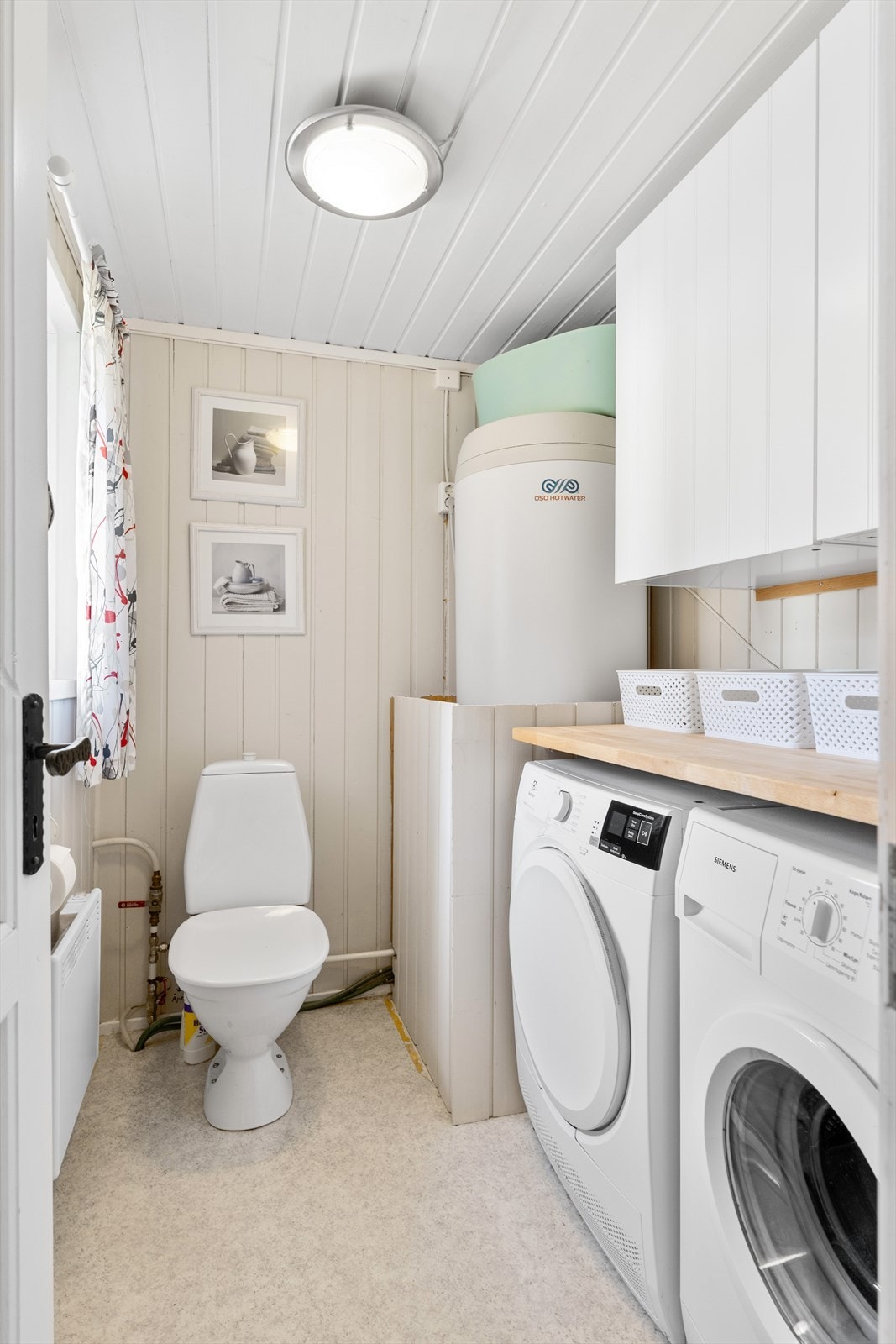 Fra badet har man direkte tilgang til et praktisk vaskerom med god plass til både vaskemaskin, tørketrommel og oppbevaring. Galleribilde