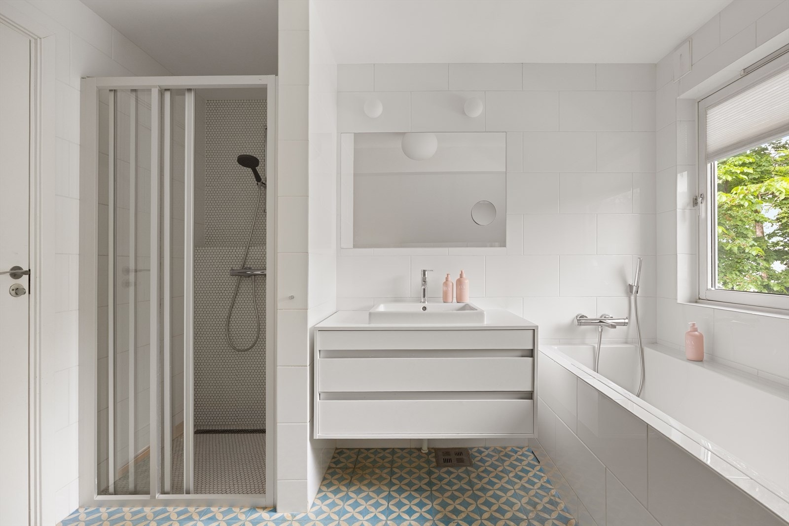 Badet har både en dusjnisje med skyvedører og et deilig, innfliset badekar med plassbygde hyller for håndklær eller dekorelementer. Galleribilde