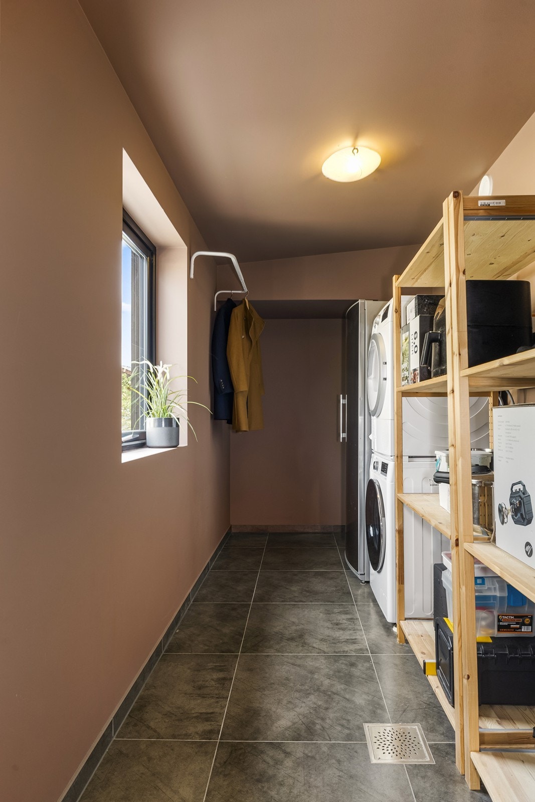 Tvers over gangen fra badet i 1. etasje ligger vaskerom med flislagt gulv og røropplegg for vaskemaskin. Galleribilde