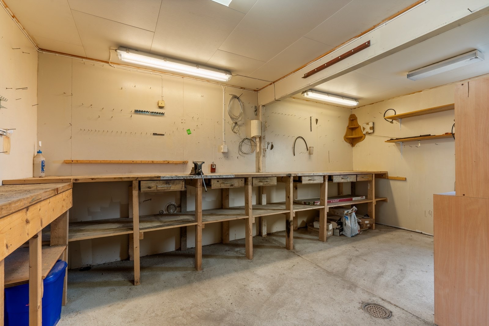 Verksteddelen i garasjen er utstyrt med solide arbeidsbenker og har innlagt strøm og varme i gulvet. Galleribilde