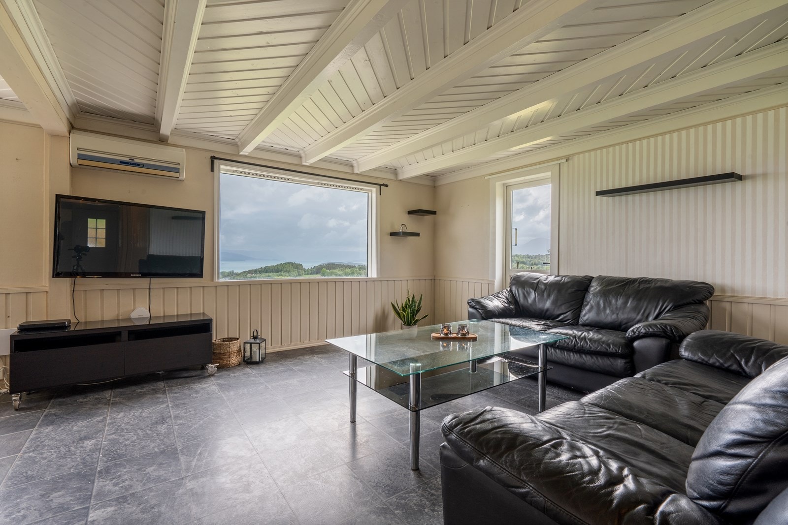 Store vindusflater gir godt med lys og rammer inn utsikten mot fjorden. Galleribilde