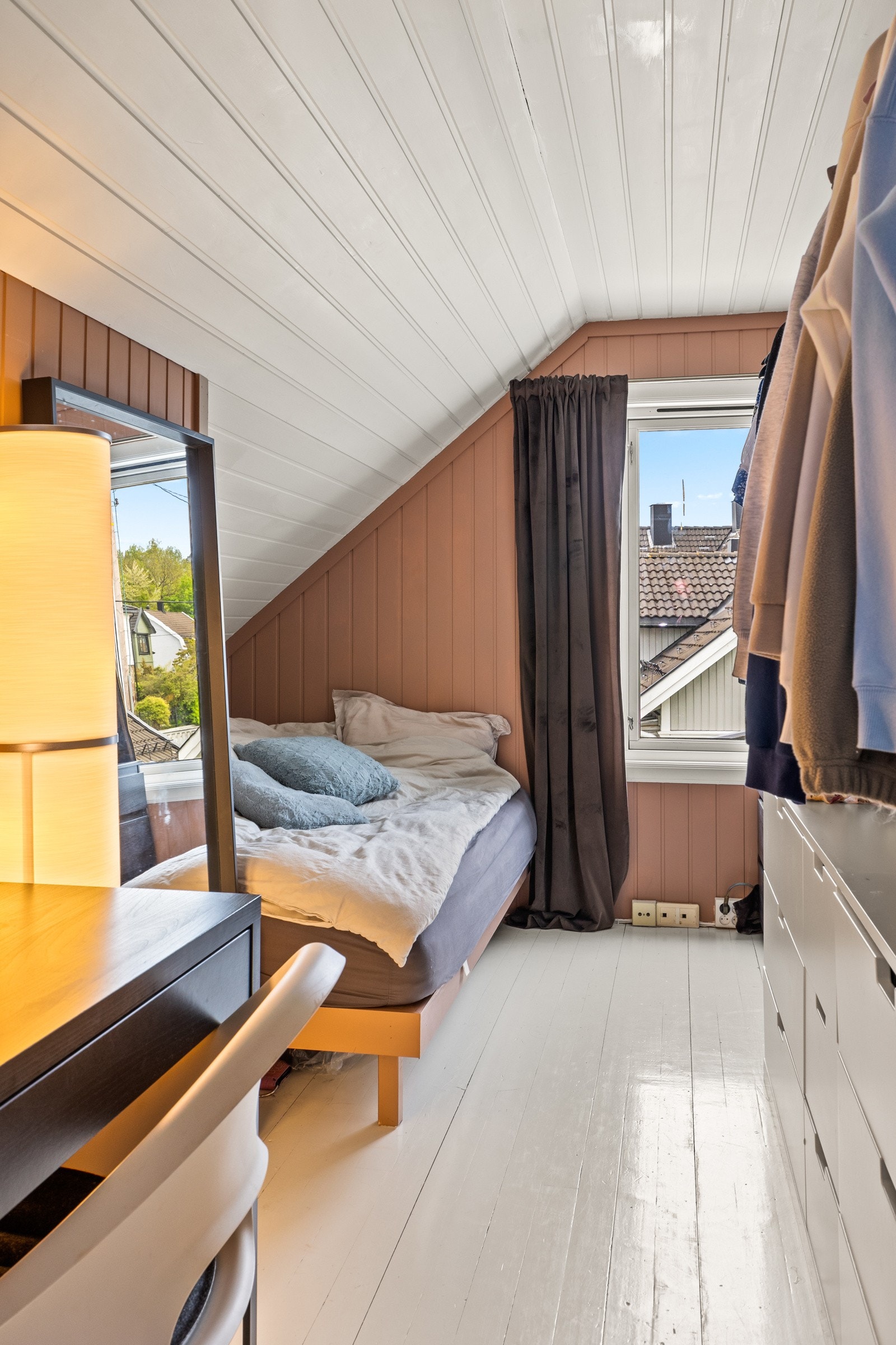 Soverom 3 i loftsetasjen, også med varme fargetoner, skråtak og plass til både seng og oppbevaringsløsninger. Galleribilde