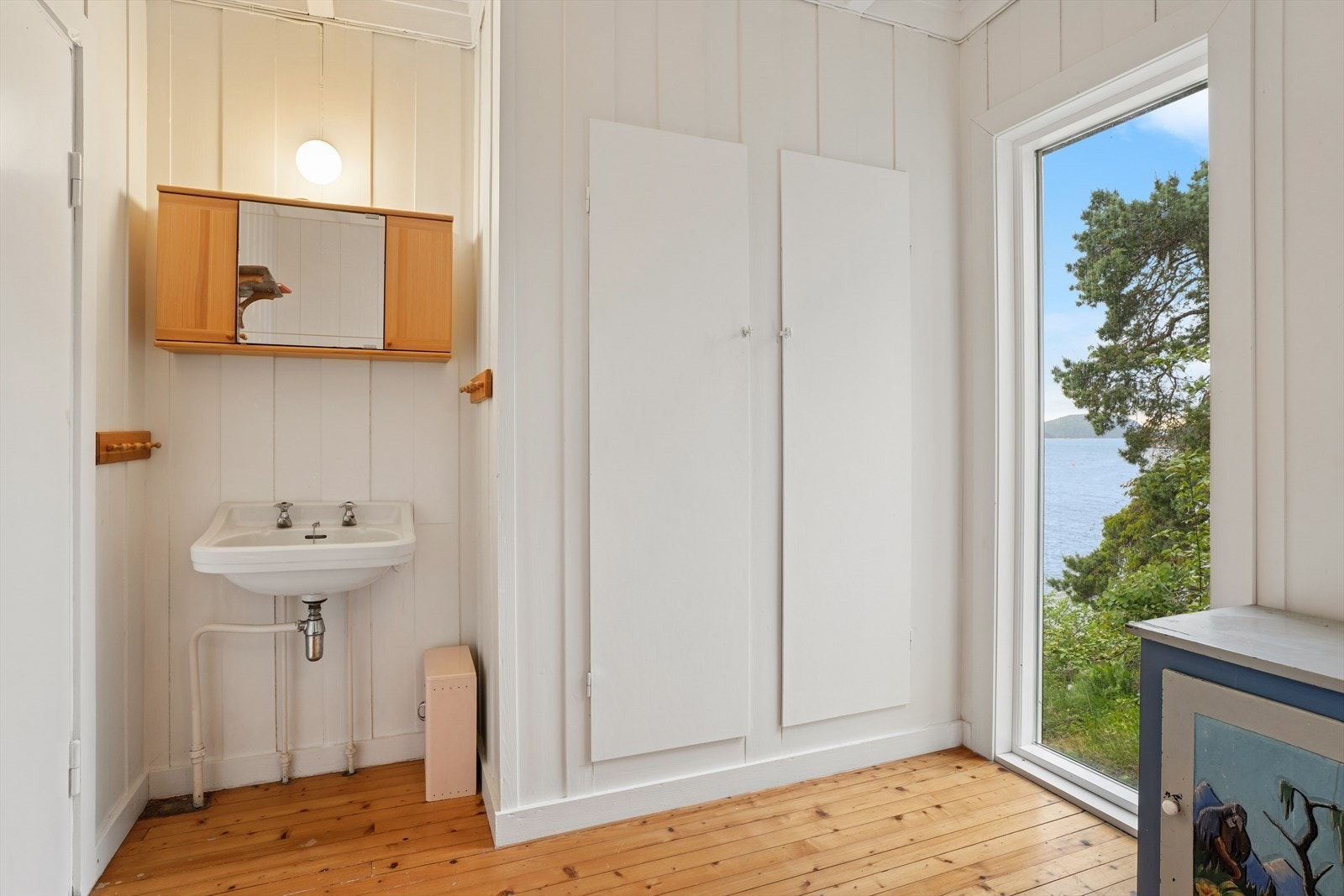 Detalj fra et av soverommene, som viser servant og plassbygd skap. Galleribilde