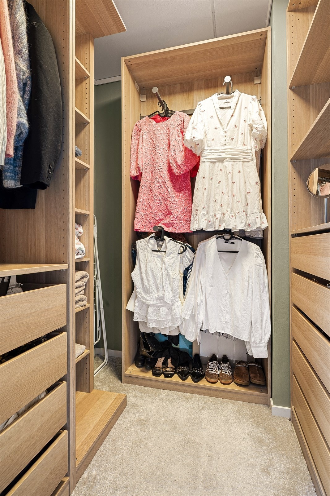 Rommet har teppe på gulv og PAX-garderobe fra IKEA, som gjør det enkelt å tilpasse oppbevaringen etter egne behov. Galleribilde